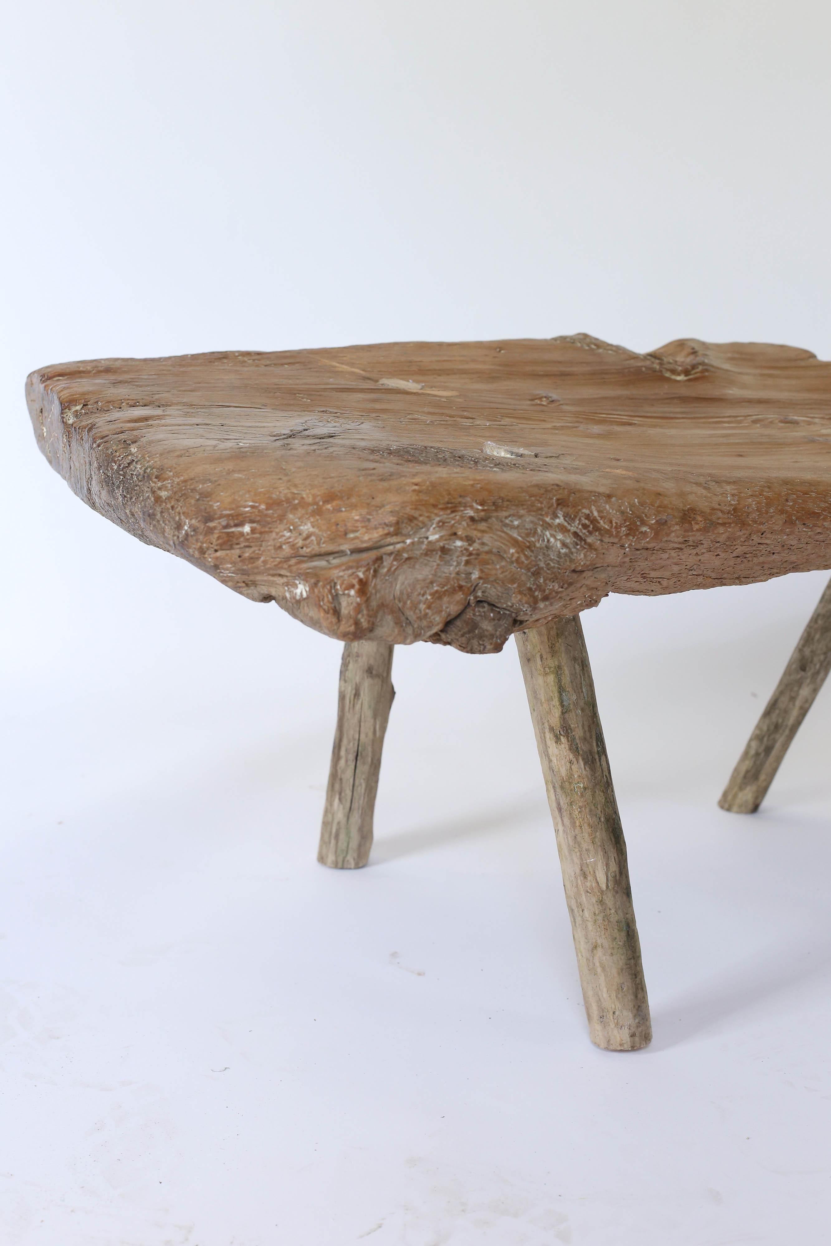 A rustic handmade low table or bench found in France. Heavy and sturdy, a treat for the eye from every angle. Made from one plank of wood the 3 inch top is the focal point with the natural interest of the wood. A warm and interesting piece which