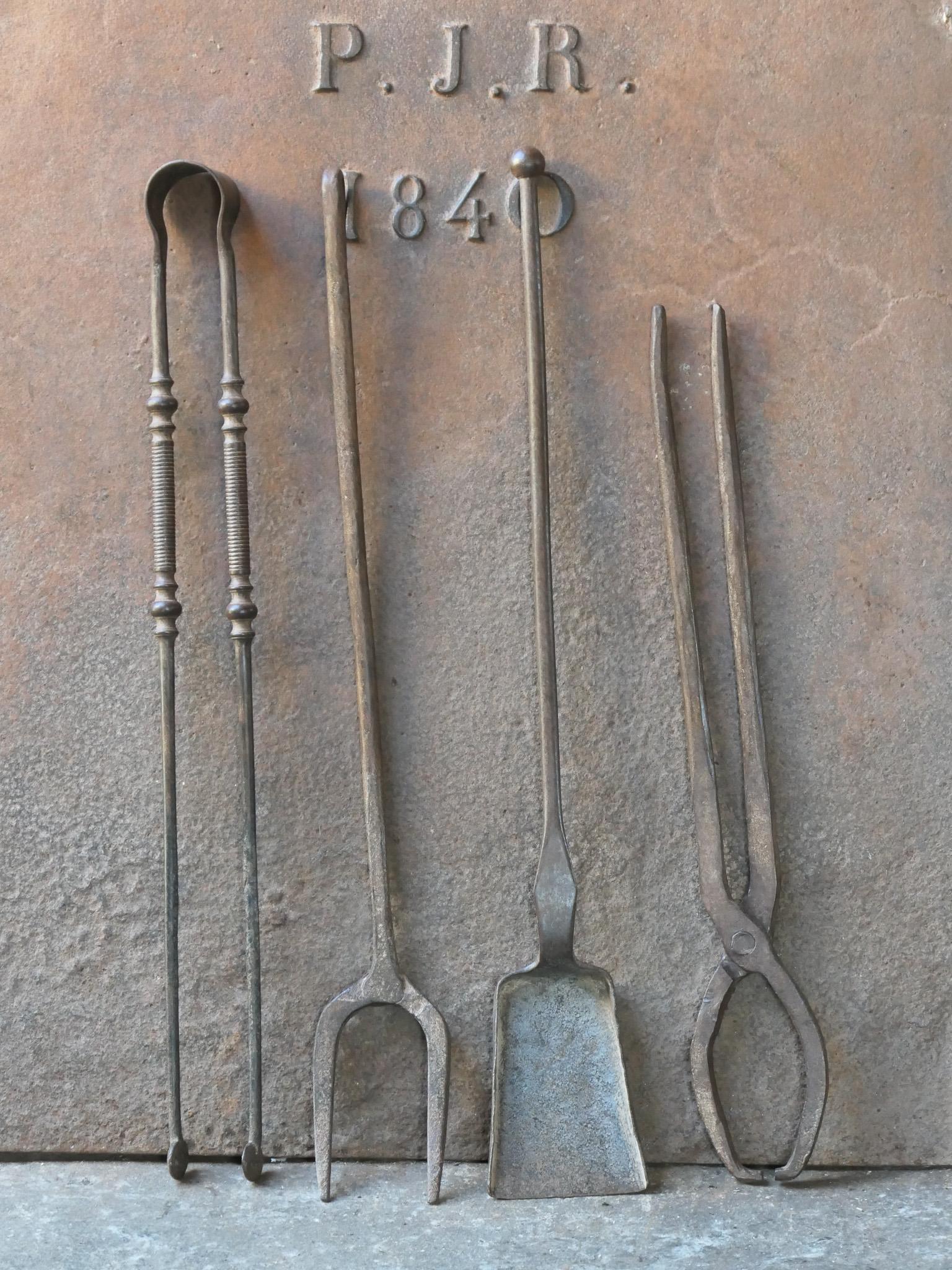 Rustic 18th-19th century French fireplace tool set. The tool set consists of fireplace tongs, shovel, a fire fork and log tongs. The tools are made of wrought iron. The set is in a good condition and fit for use in the fireplace.