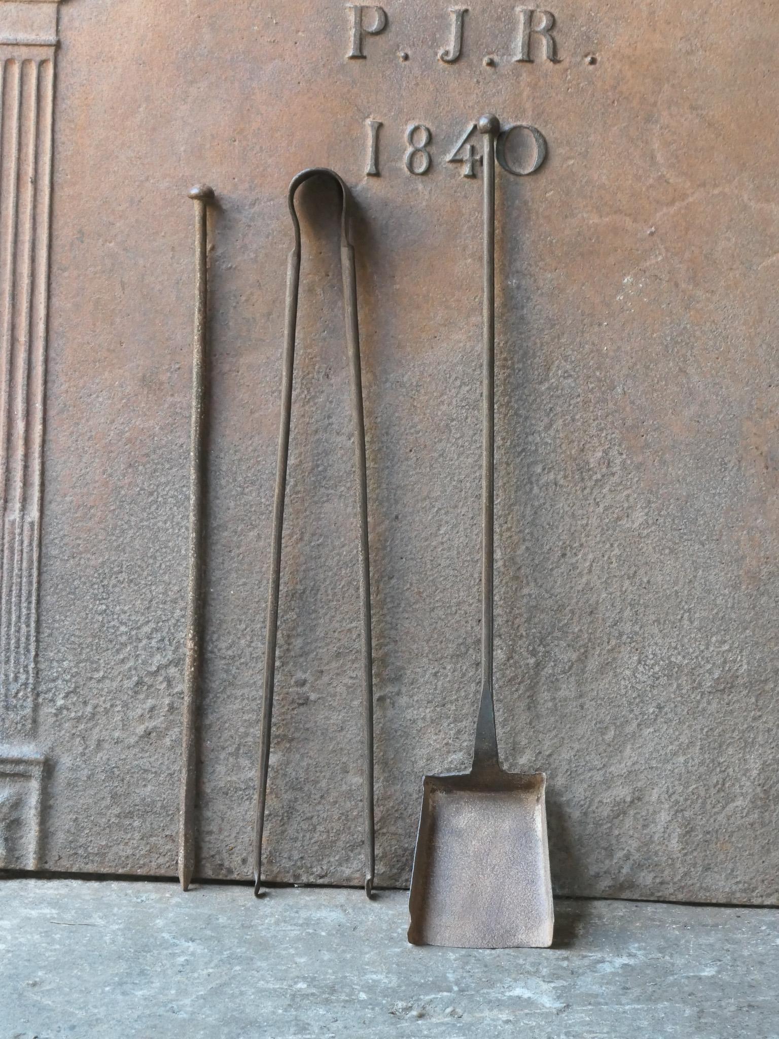 Ensemble d'outils de cheminée rustique français du 18e-19e siècle. L'ensemble d'outils comprend une pince à cheminée, une pelle et un tisonnier. Les outils sont en fer forgé. L'ensemble est en bon état et apte à être utilisé dans la cheminée.
