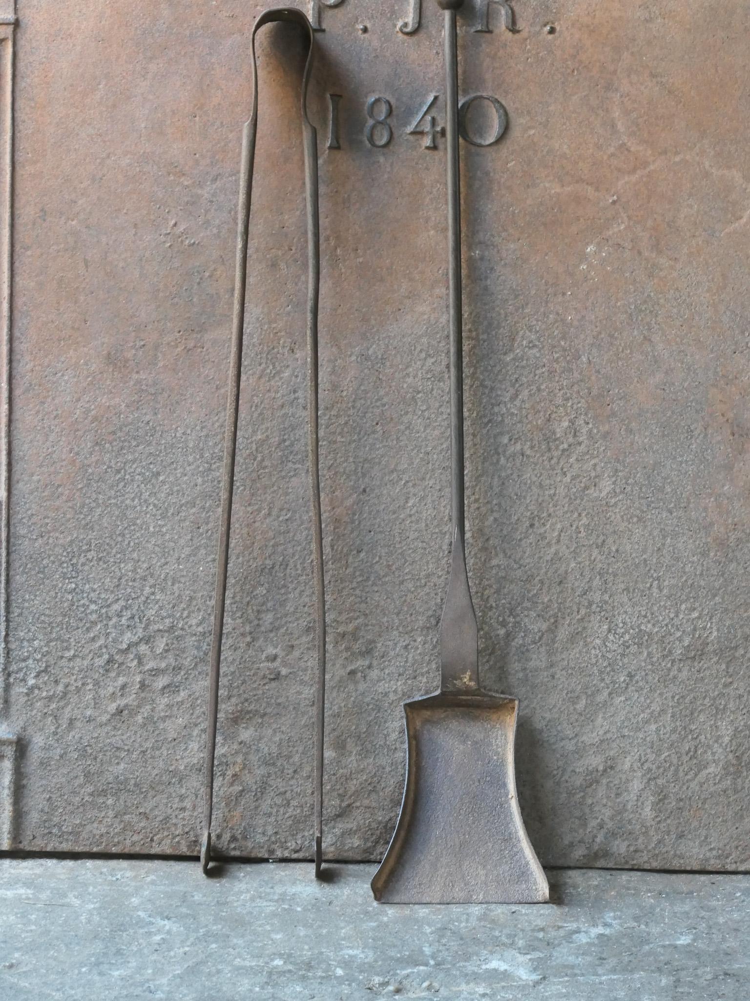 Ensemble d'outils de cheminée rustique français du 18e-19e siècle. Le set d'outils se compose d'une pince à cheminée et d'une pelle. Les outils sont en fer forgé. L'ensemble est en bon état et apte à être utilisé dans la cheminée.