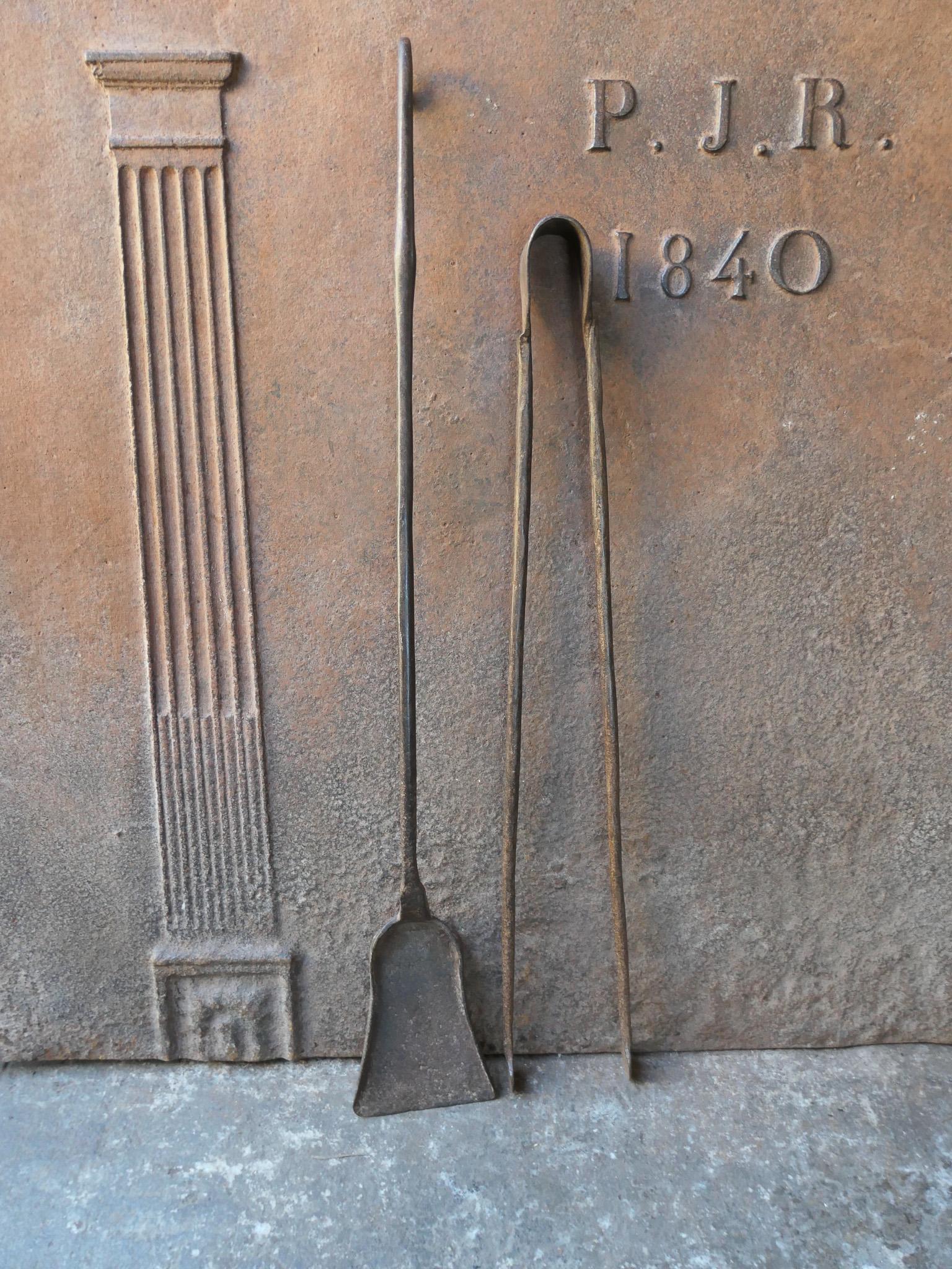 Rustic 18th century French fireplace tool set. The tool set consists of fireplace tongs and a shovel. The tools are made of wrought iron. The set is in a good condition and fit for use in the fireplace.