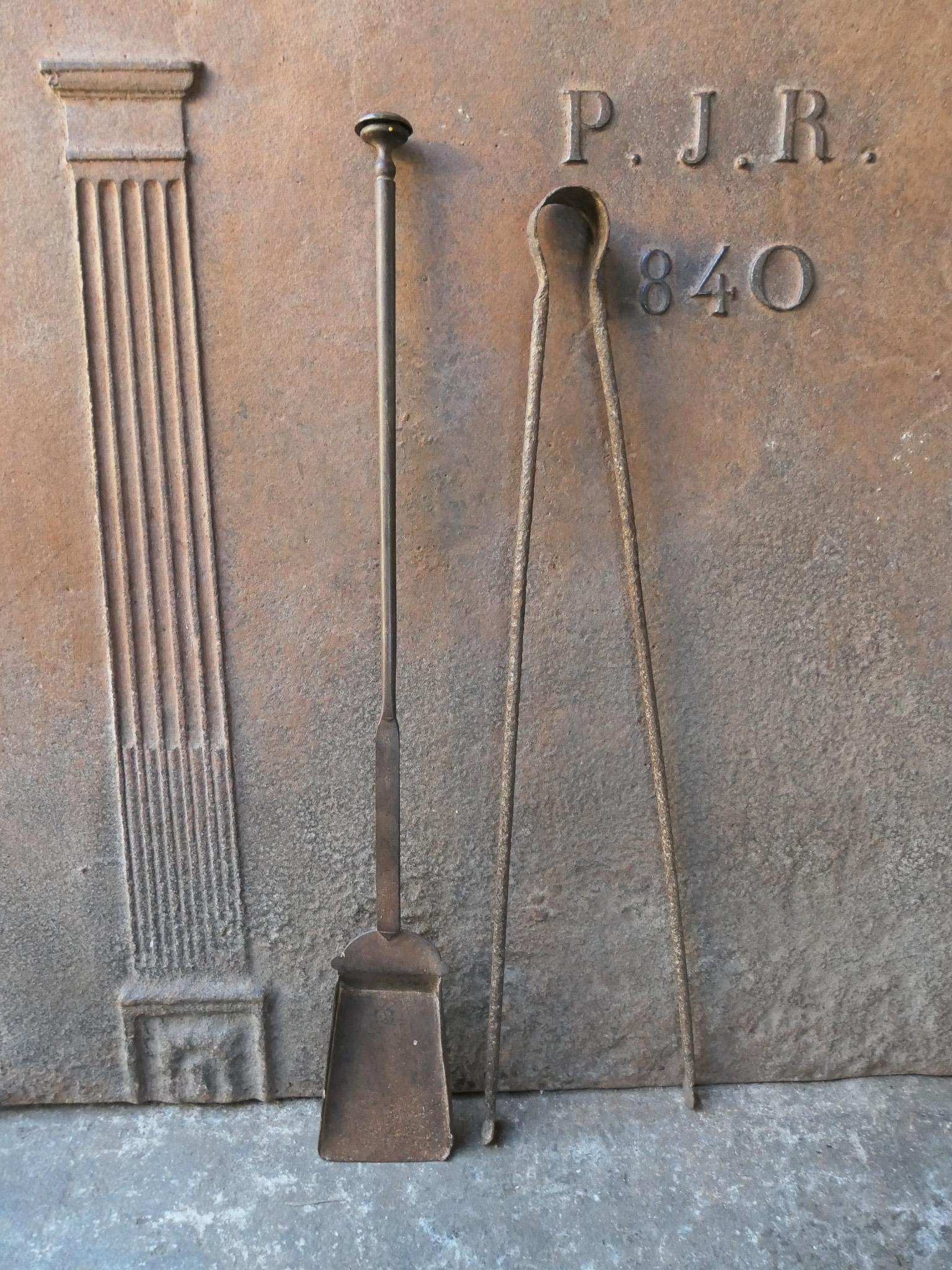 Rustic 18th-19th century French fireplace tool set. The tool set consists of fireplace tongs and a shovel. The tools are made of wrought iron. The set is in a good condition and fit for use in the fireplace.