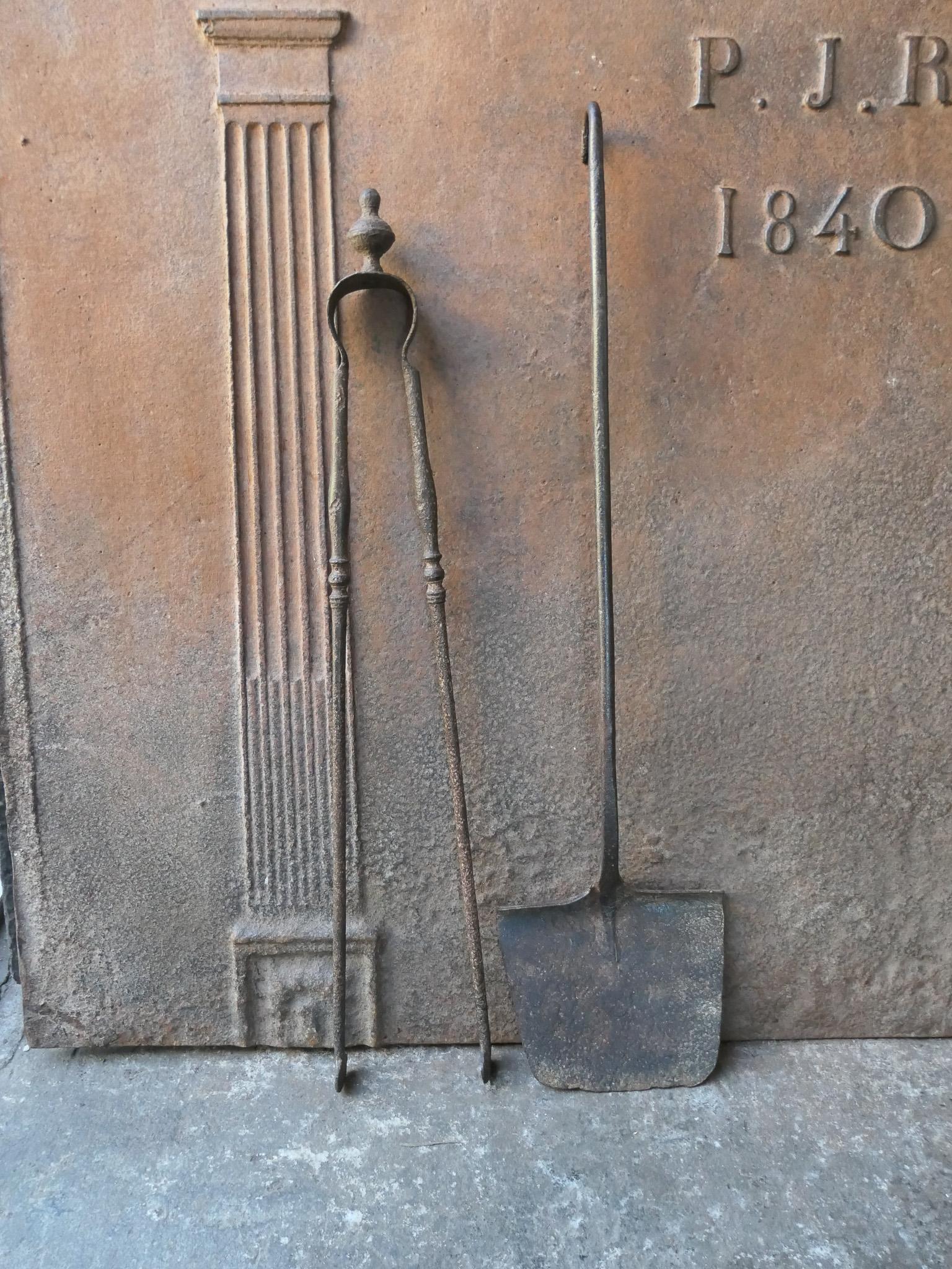 Rustic 18th-19th century French fireplace tool set. The tool set consists of fireplace tongs and a shovel. The tools are made of wrought iron. The set is in a good condition and fit for use in the fireplace.