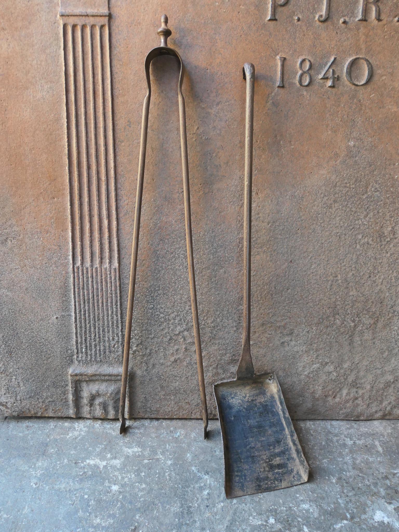 Rustic 18th-19th century French fireplace tool set. The tool set consists of fireplace tongs and a shovel. The tools are made of wrought iron. The set is in a good condition and fit for use in the fireplace.