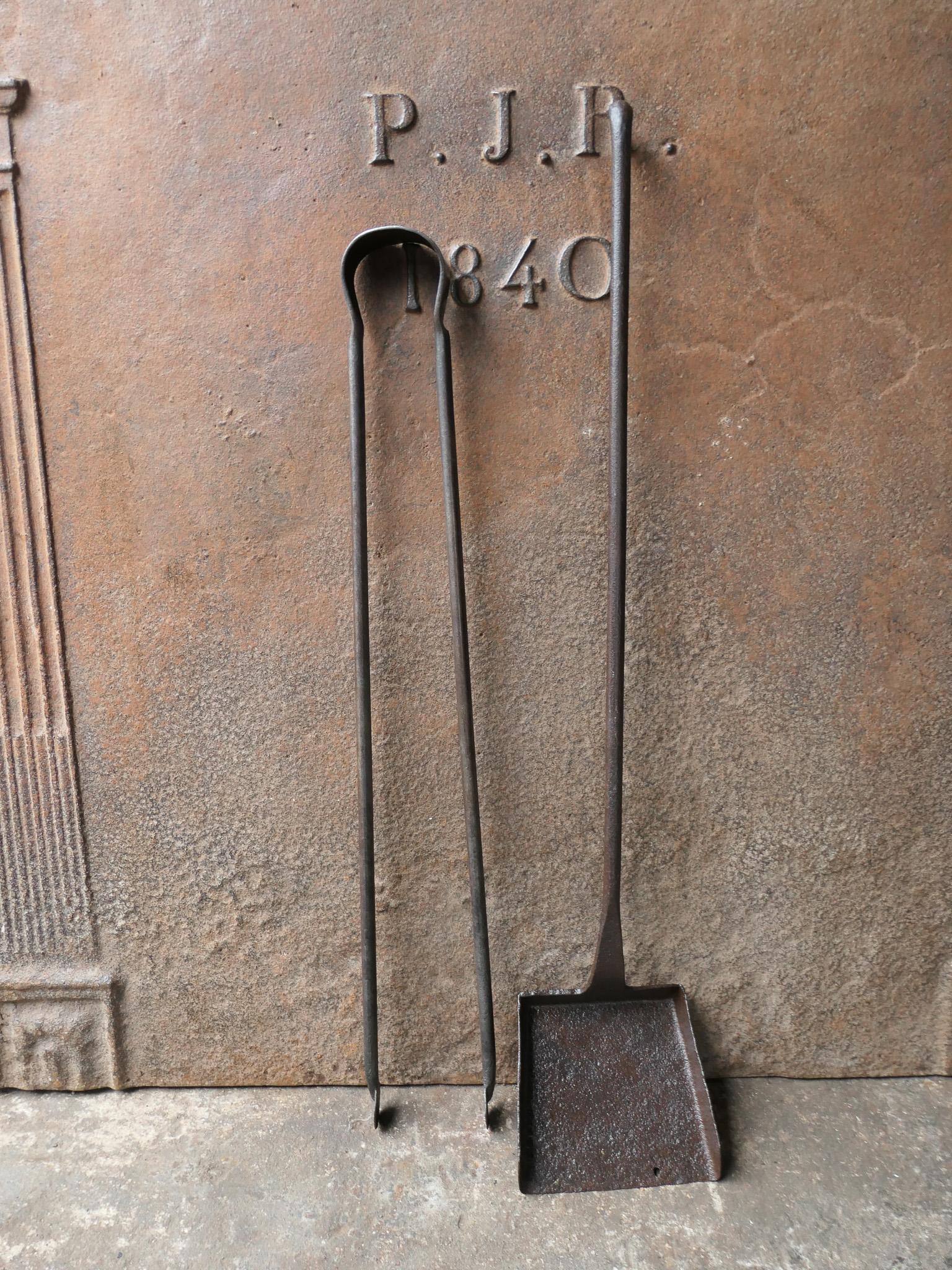 Ensemble d'outils de cheminée rustique français du 18e-19e siècle. Le set d'outils se compose d'une pince à cheminée et d'une pelle. Les outils sont en fer forgé. L'ensemble est en bon état et apte à être utilisé dans la cheminée.