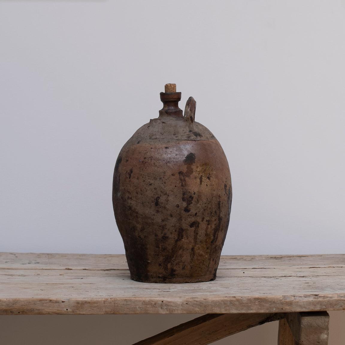 A rustic French pottery jug with a cork lid from Late 19th century, with great patina.
One pf the handles is broken and missing, but the rustic appearance is still great.
The right one in the last two pictures.