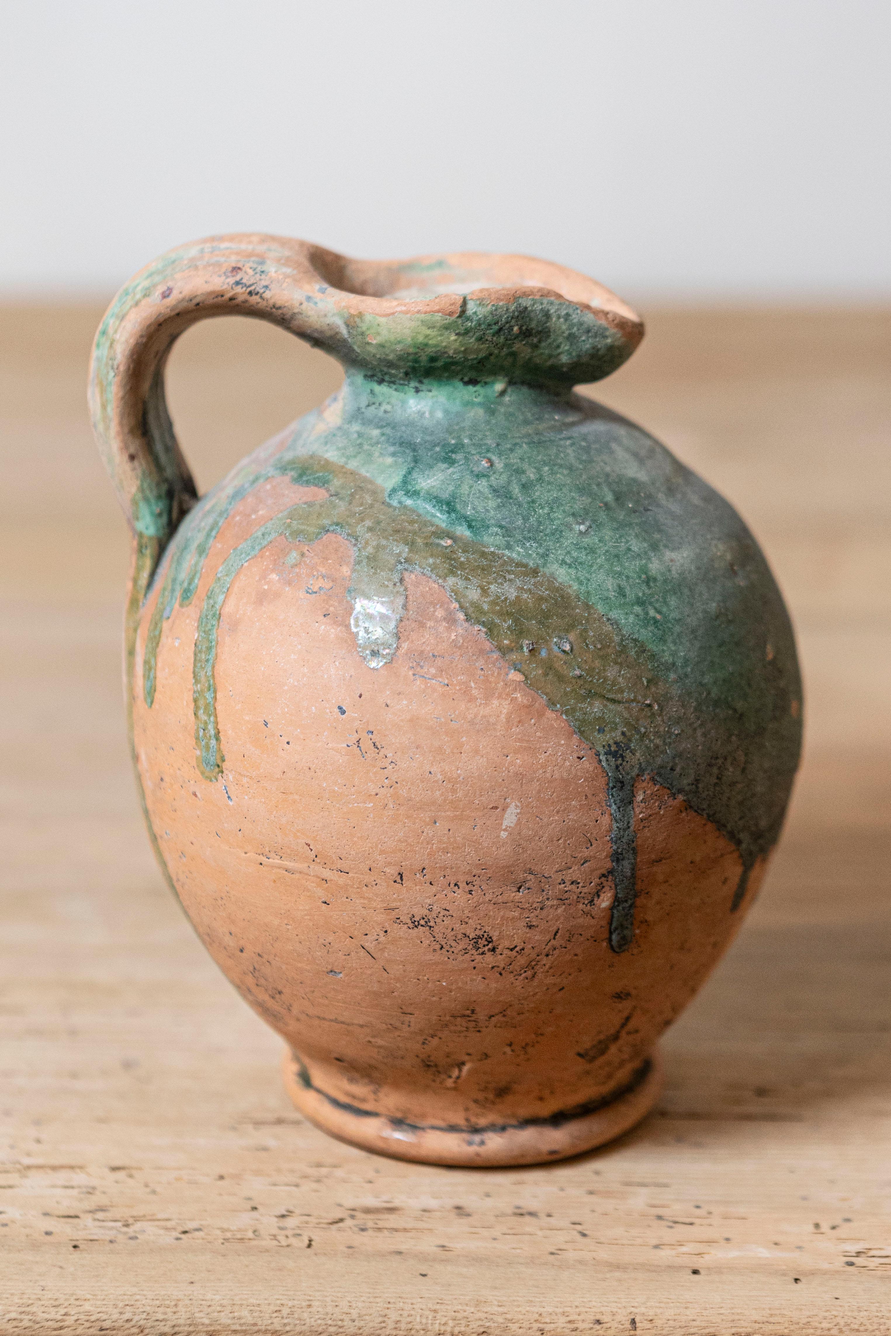 Brocca in ceramica provinciale francese del XIX secolo con accenti smaltati di verde e manico posteriore modellato. Immergiti nel fascino pastorale di questa brocca in ceramica della provincia francese, risalente al XIX secolo. Con le sue linee