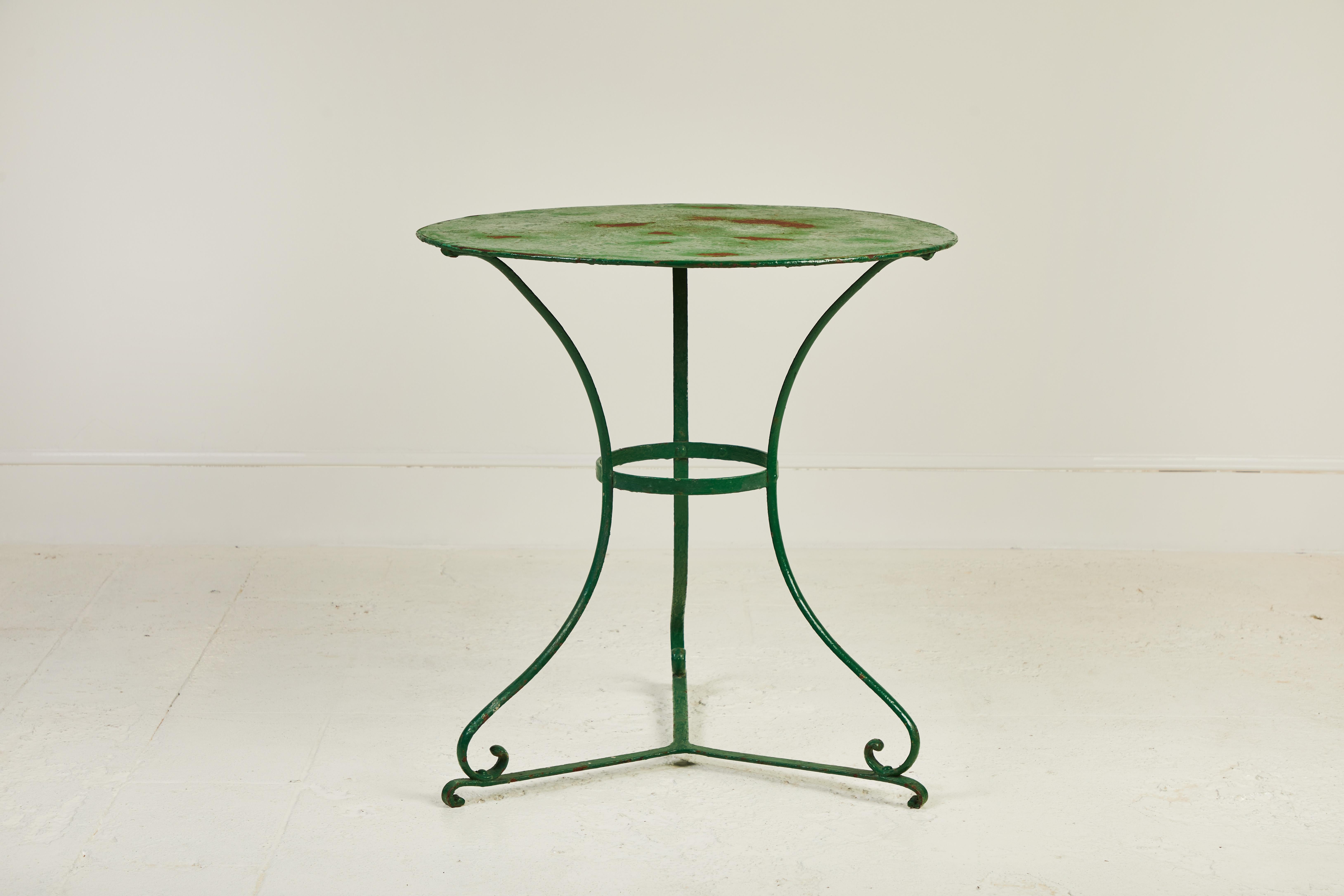 Rustic French round green metal table, the top has some beautiful age and patina. Scrolled base adds a bit of whimsy.
