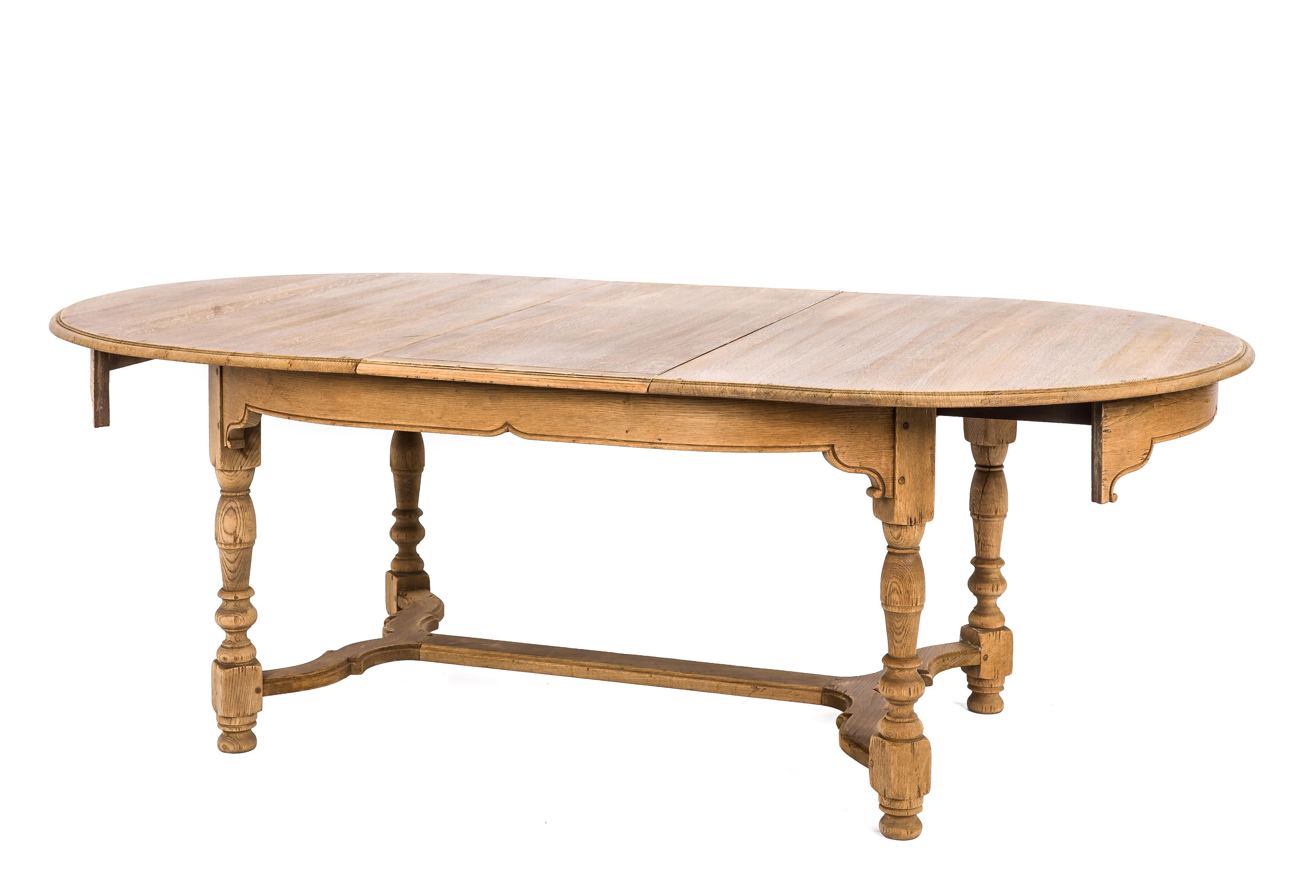 This beautiful rustic table was made in France in the department of Sarthe in the 1960s. The table was made in French summer oak in Louis Philippe style. It has turned legs joined by a scrolled stretcher. The table can be extended by inserting two