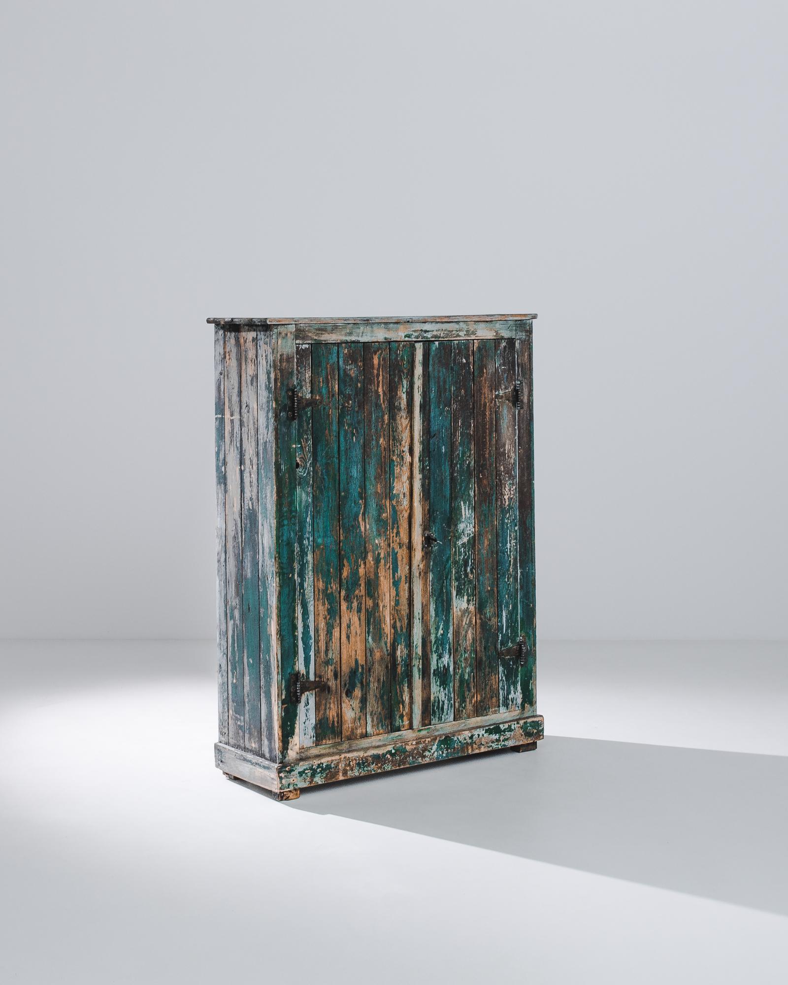 A wooden cabinet produced in France circa 1900. At nearly five feet tall, this wooden chest with layers of original patination. Streaks of blue and teal, evidence of a long life, of international intrigue. Deceptively simple, this ingeniously