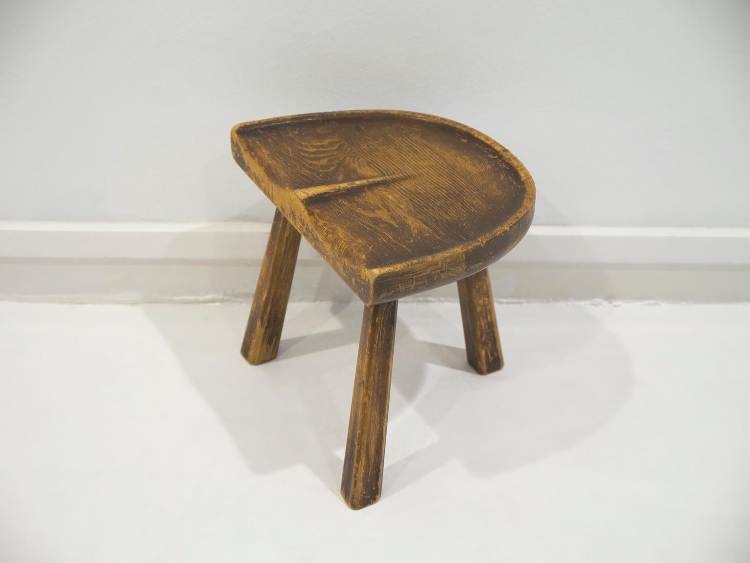 Sgabello vintage in legno realizzato in Francia negli anni '50. Lo sgabello ha una seduta ergonomica e tre gambe, che ricordano un semplice sgabello da latte. Ideale per decorare aree rustiche.