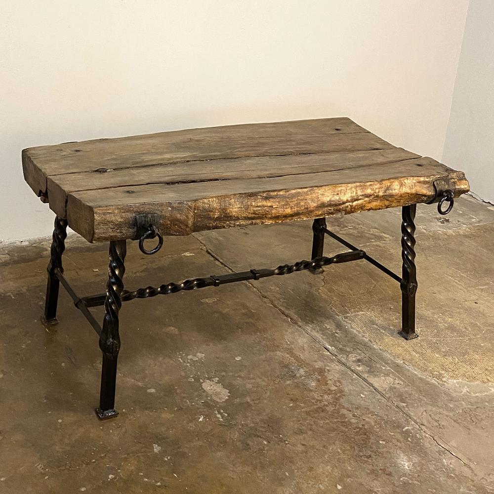 Rustic French wrought iron and Timber coffee table was crafted to last for centuries, made from very old timbers of solid old-growth oak, and fitted with hand-forged iron rings to assist in moving the table, as well as a finely crafted stand with