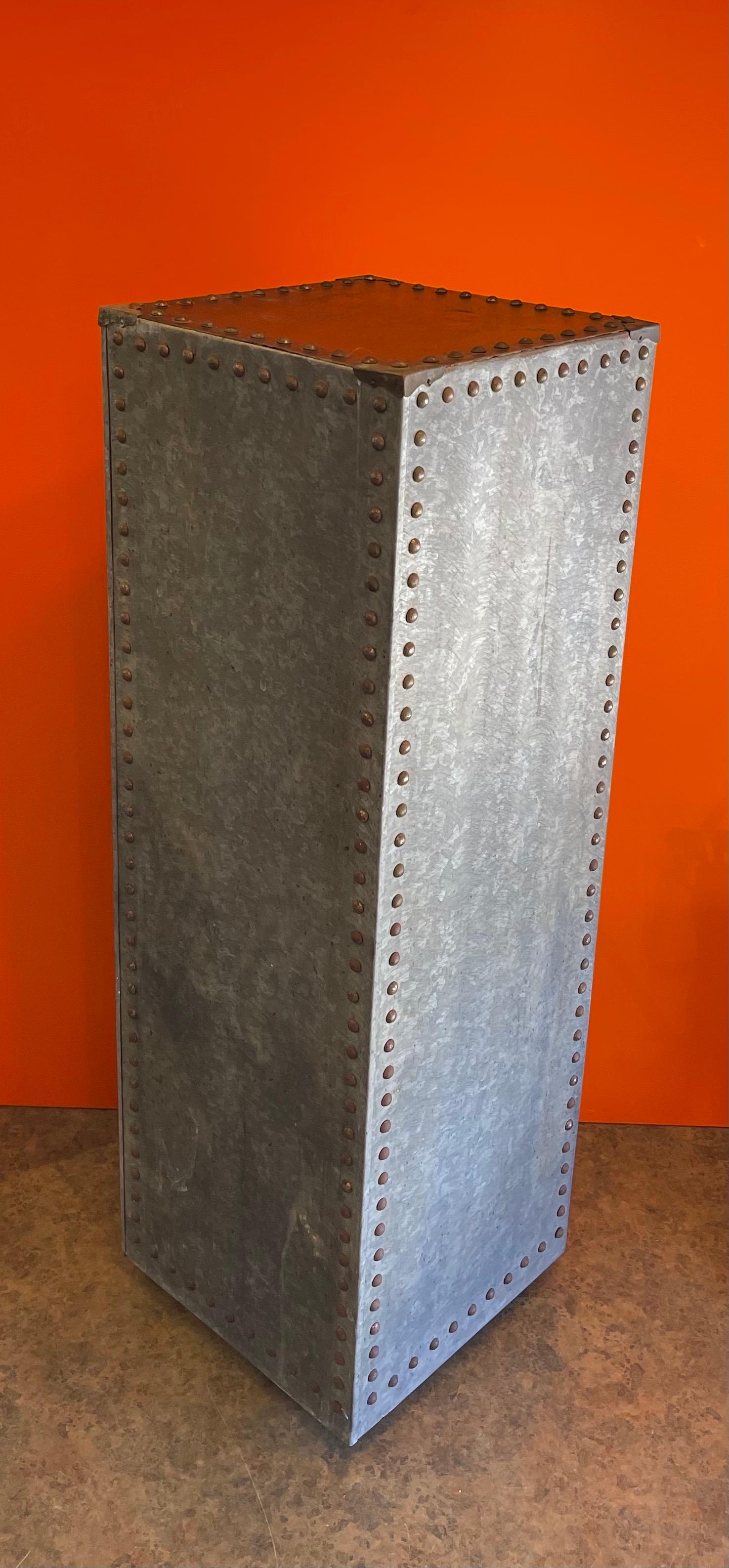 Rustic galvanized sheet metal and rivets pedestal, circa 1980s. The piece measures 12