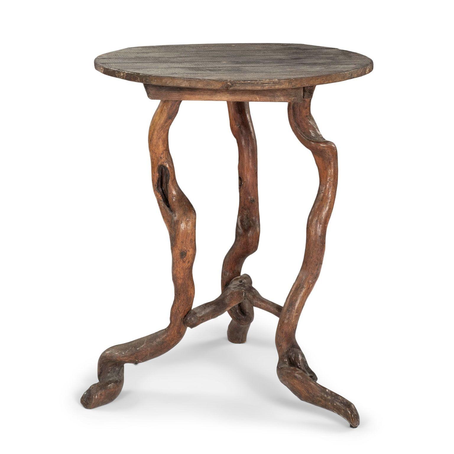 Rustic garden table with root wood base circa 1910-1929, France. Round wooden top with remnants of early painted finish. Root wood three-legged base.