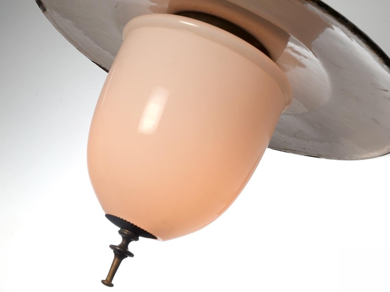 This large showy but simple white porcelain gas lamp (now wired for a standard bulb) has its original patina. It is fitted with a unique elongated milk glass shade and decorative bottom holder. The shade has an 18