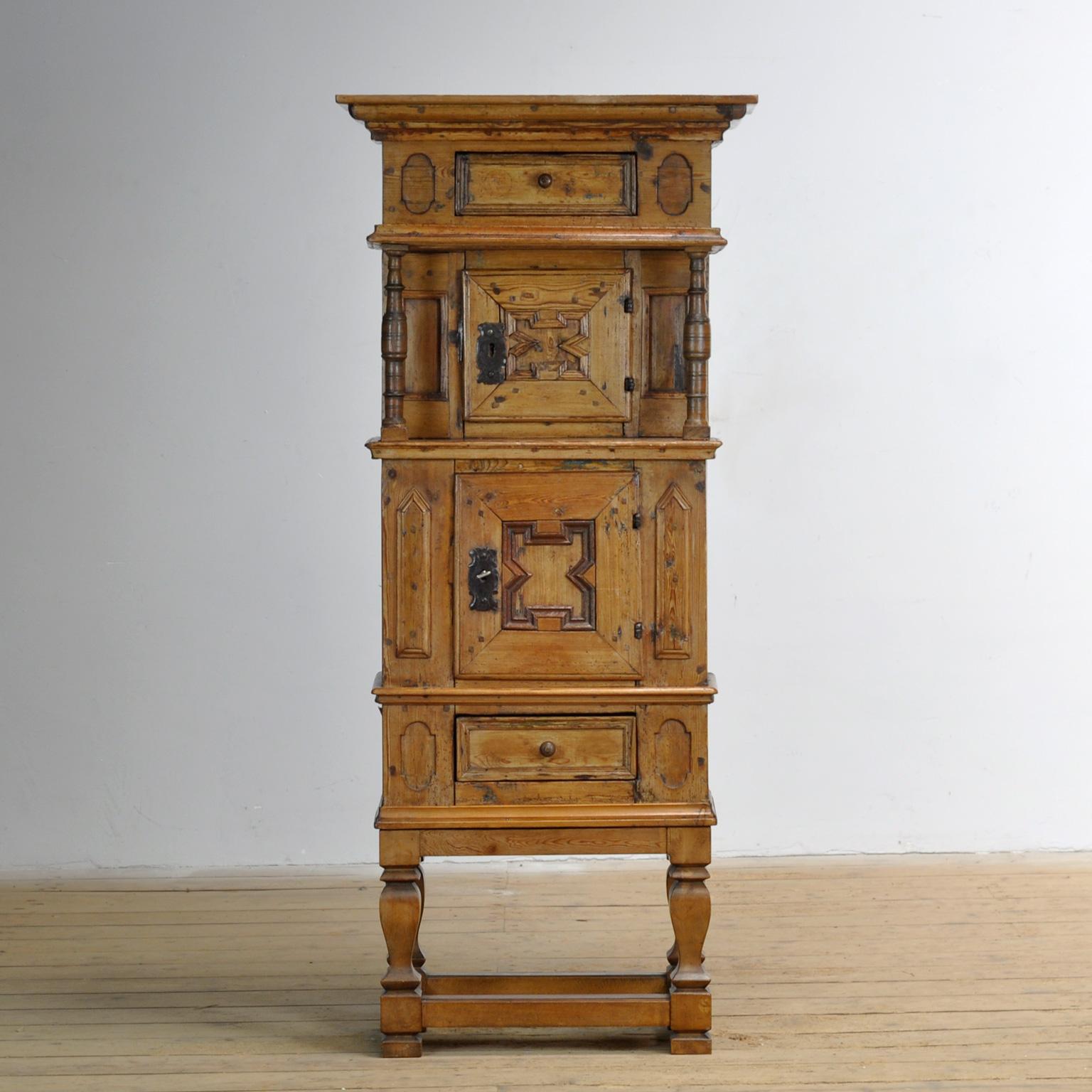 A small cabinet, made in Germany. This piece has a rustic character and is made of pine with an oak base. The cabinet was made around 1850. It has two drawers and two doors with a simple cornice. The whole stands on an oak base.

If you’re