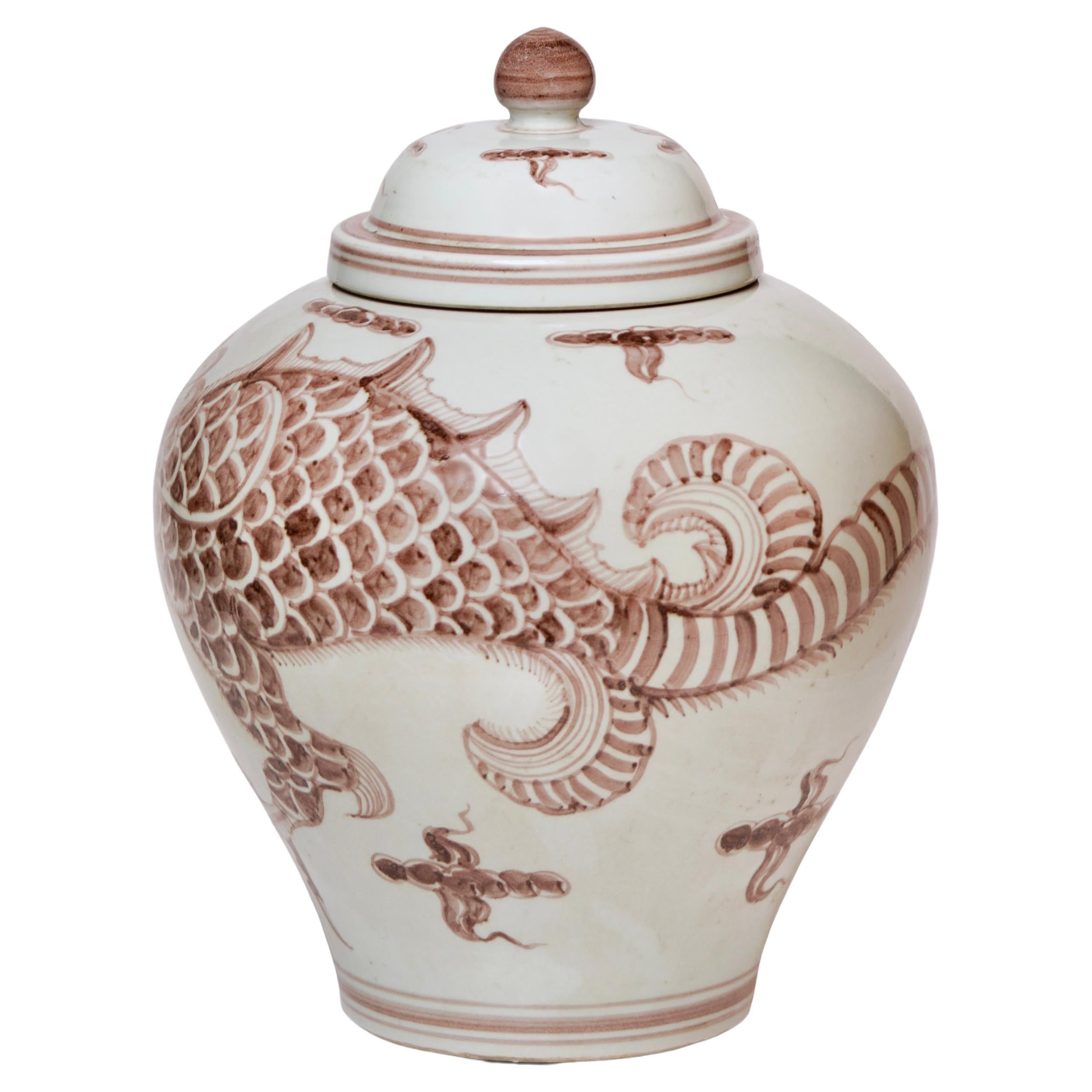 This temple jar is a traditional porcelain vessel from Jingdezhen, a town long distinguished by imperial patronage. The rustic finish porcelain body has been painted with a lively Yuan Dynasty style 