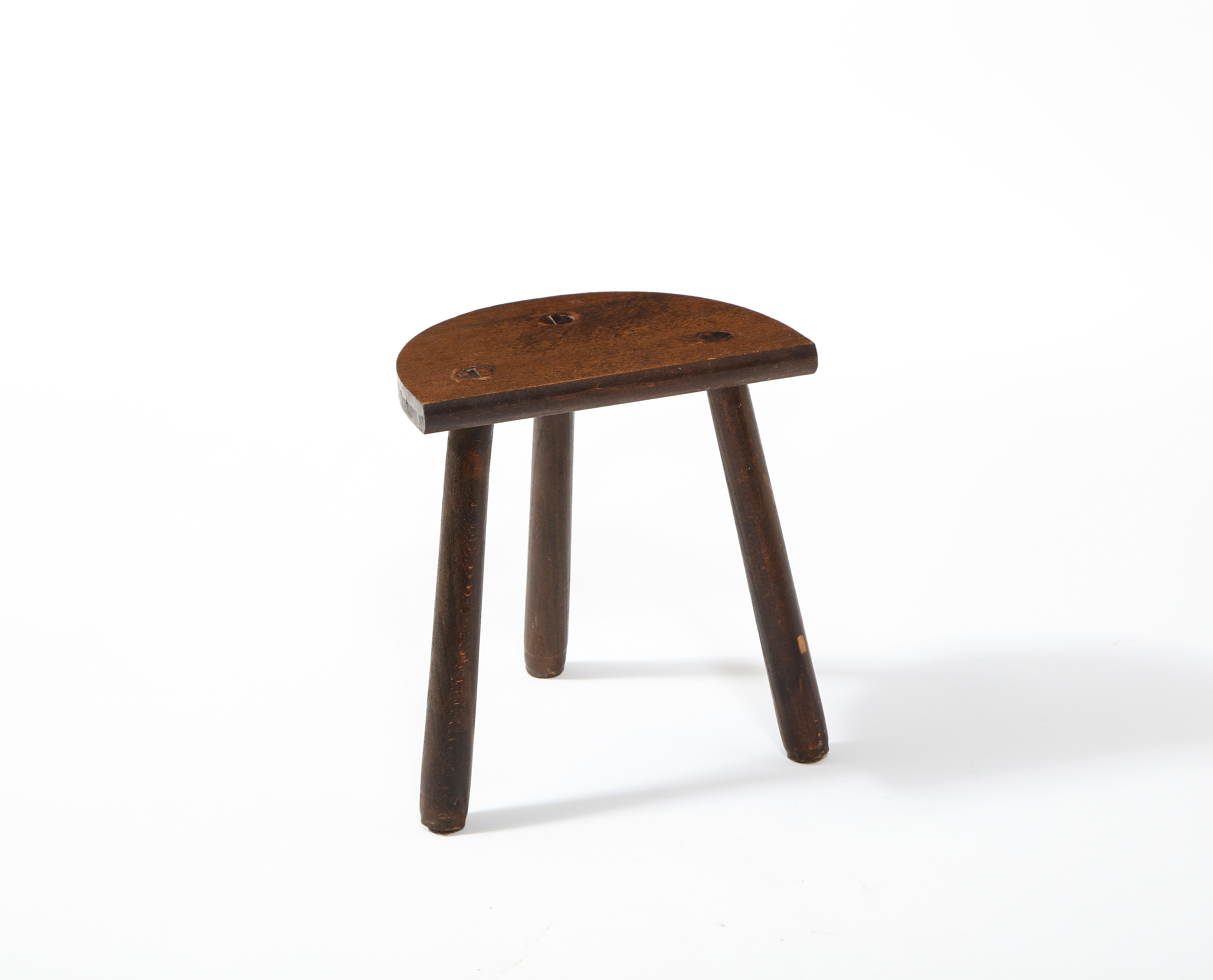 A carved Elm farm tripod stool. The unique semi-circle seat and angled legs add a modern touch to an, otherwise, rustic piece.