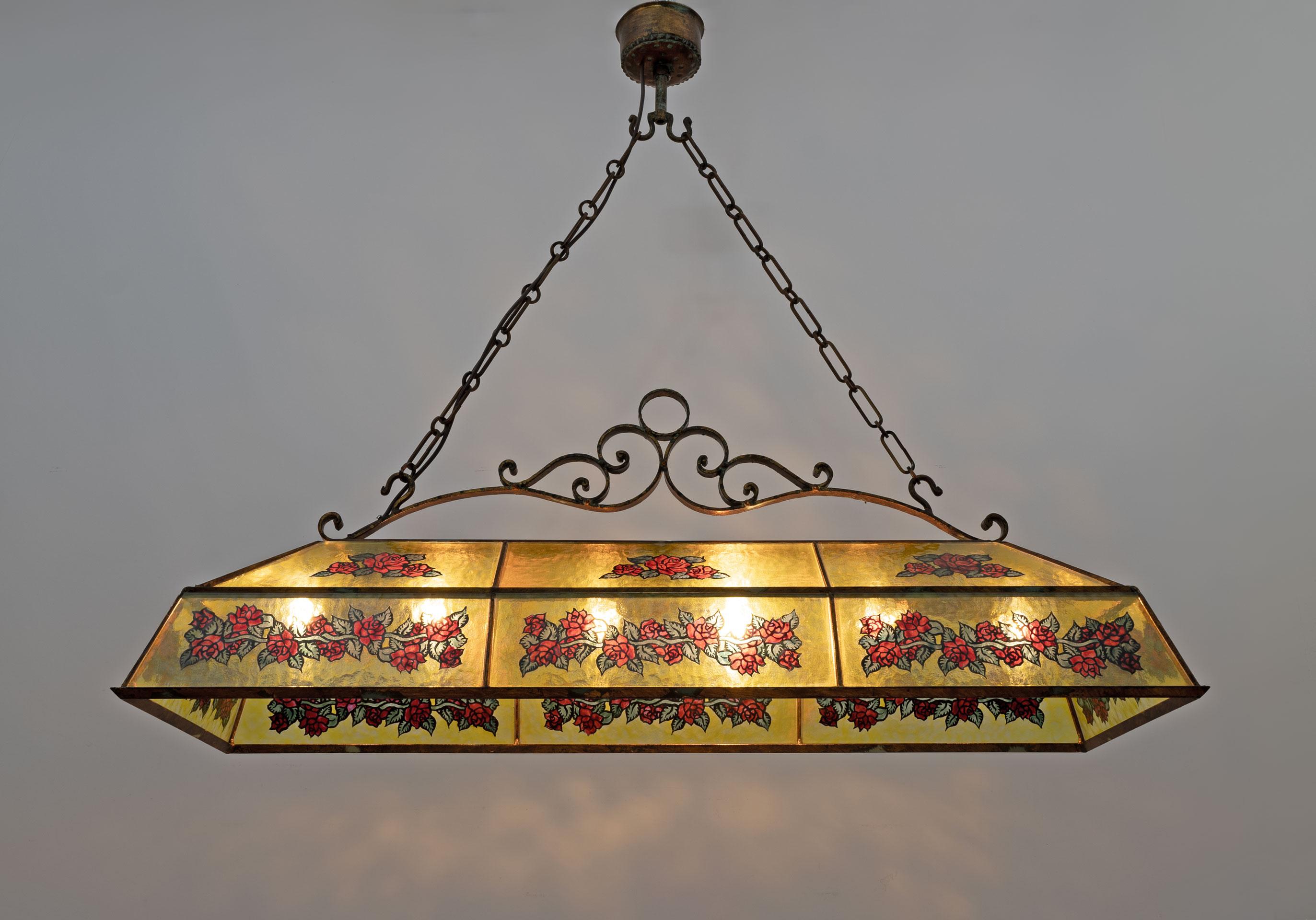 Italian rustic style chandelier in wrought iron and glass with hand-painted decorations. The chandelier is rectangular in shape suitable for illuminating a rectangular dining table or a rustic style peninsula. Six lamp holders for E27 or E26 bulbs