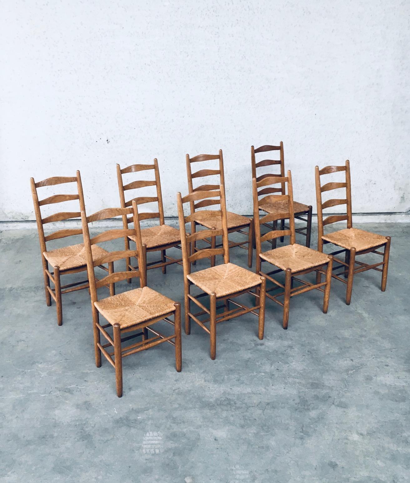 Vintage Rustic Handcrafted Oak & Rush Ladder Back Dining Chair set of 8. Made in Belgium, late 1940's, early 1950's. Solid oak constructed chair with woven rush seat. Ladder back model with several spindles in the bottom base for strenght. All