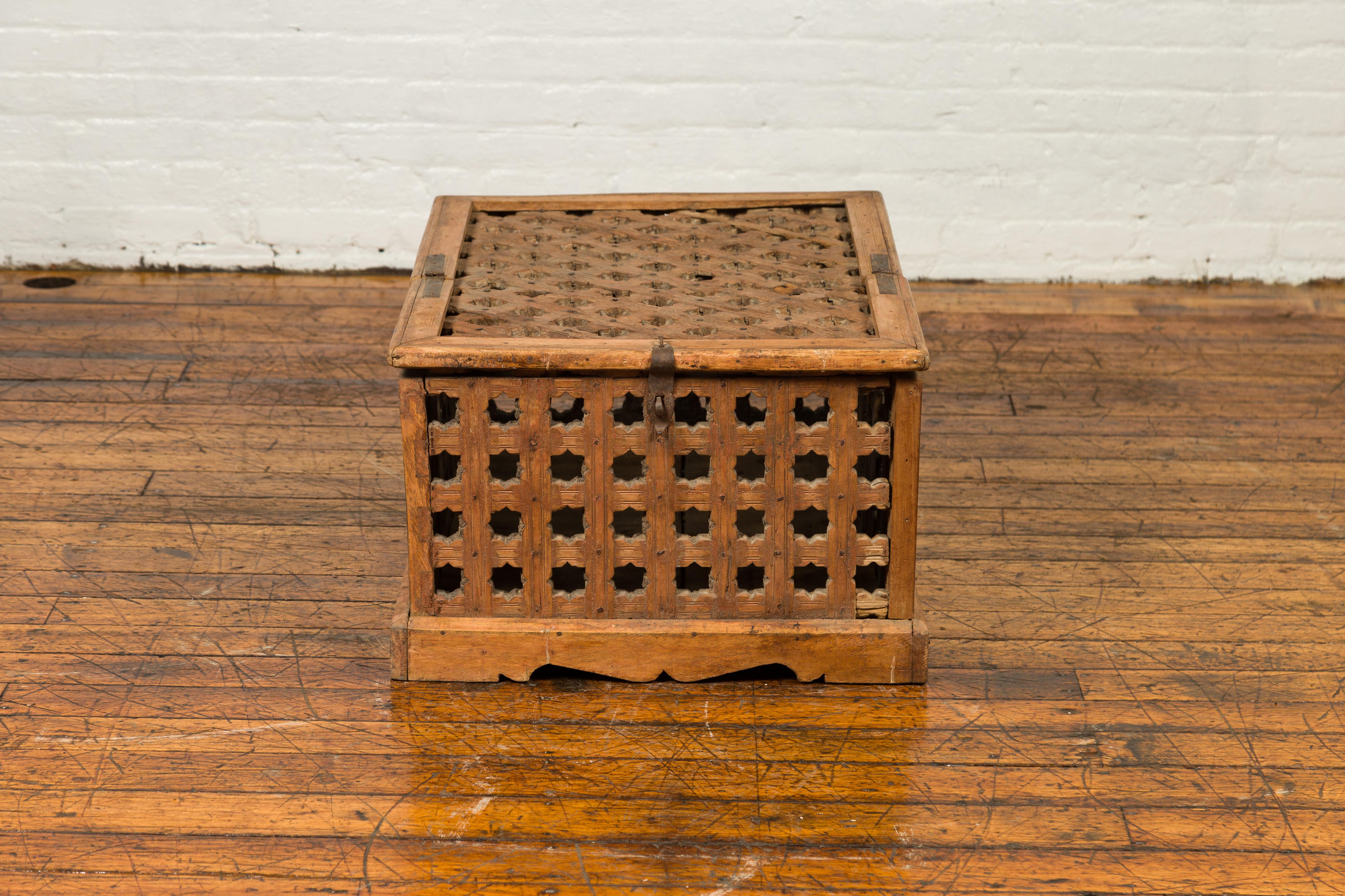 An Indian antique open food box with pierced star motifs and bracketed plinth. Crafted in India, this antique food box boasts a nicely weathered appearance. Its linear silhouette is rhythmically accented with pierced star motifs while the first half