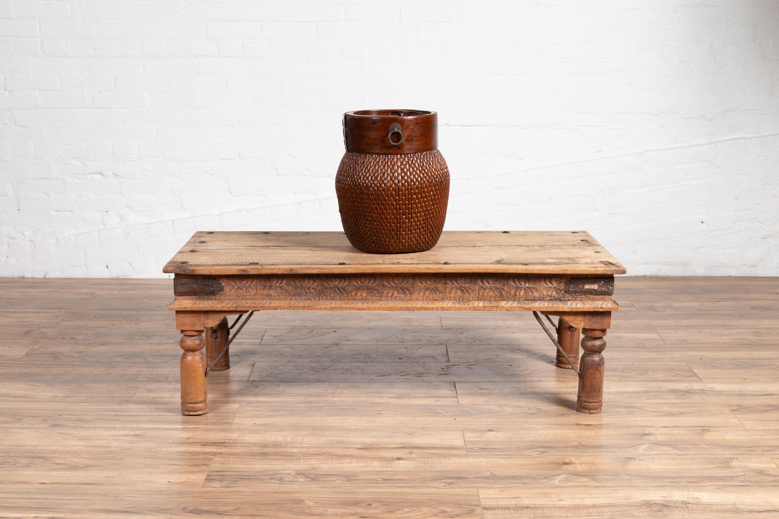 An antique rustic Indian low coffee table from the early 20th century, possibly made of sheesham wood with iron nailheads. We have several tables available with size variations. Born in India during the early years of the 20th century, this charming