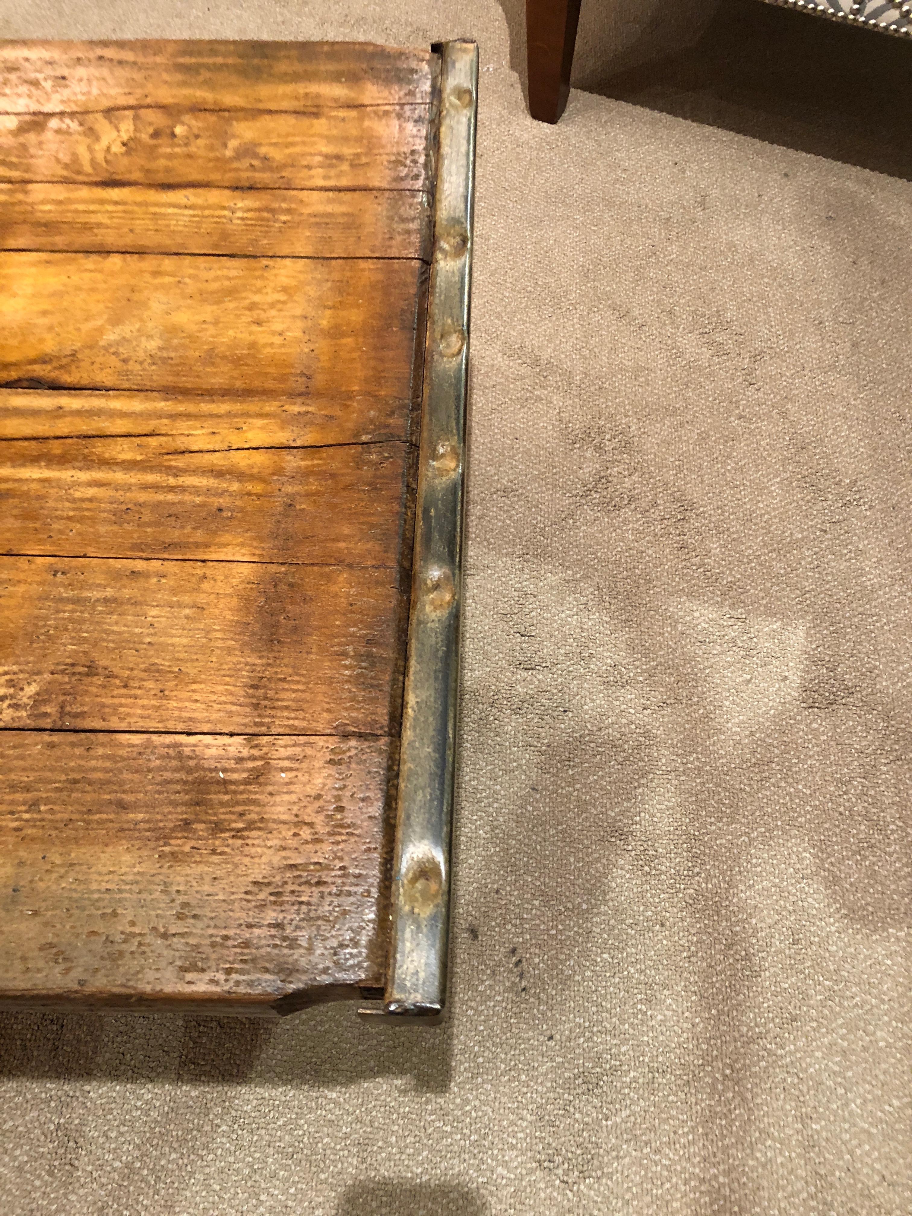 Handsome rustic wood coffee table made from a Belgian factory pallet, having original metal hardware at either end and cool iron legs.