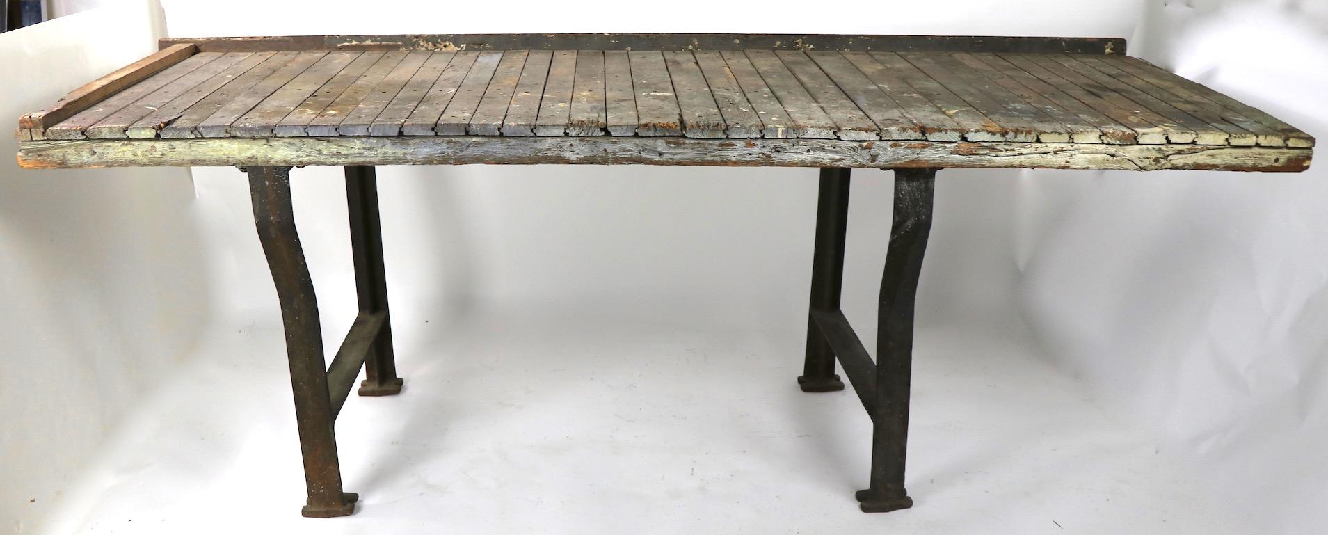 Homemade industrial, rustic large scale work table having a weathered wood top with heavy cast iron legs. Currently the legs are off center but can be repositioned to taste, legs held in place by bolts, some bolts replaced (see images).
Sturdy and