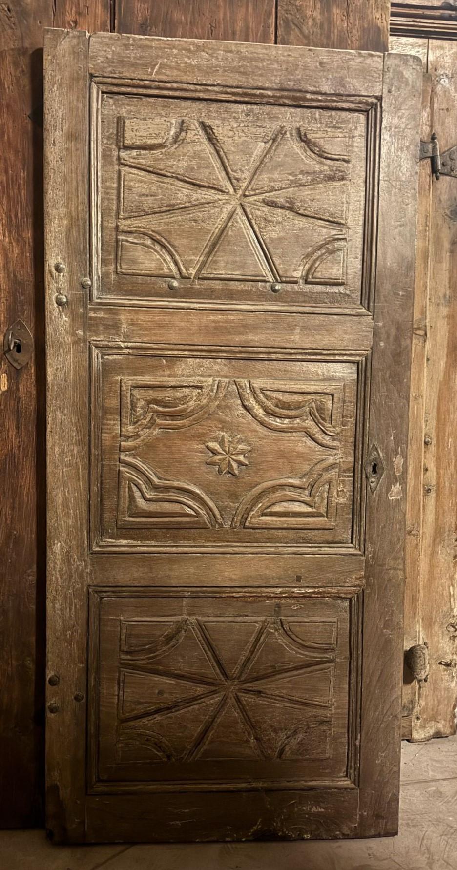 Antique interior door, rustic style given the experience, but built in solid walnut wood, with 3 hand-carved panels, smooth back, original from the 18th century, originating from upper Piedmont (Italy).
It is frameless as it was mounted directly on