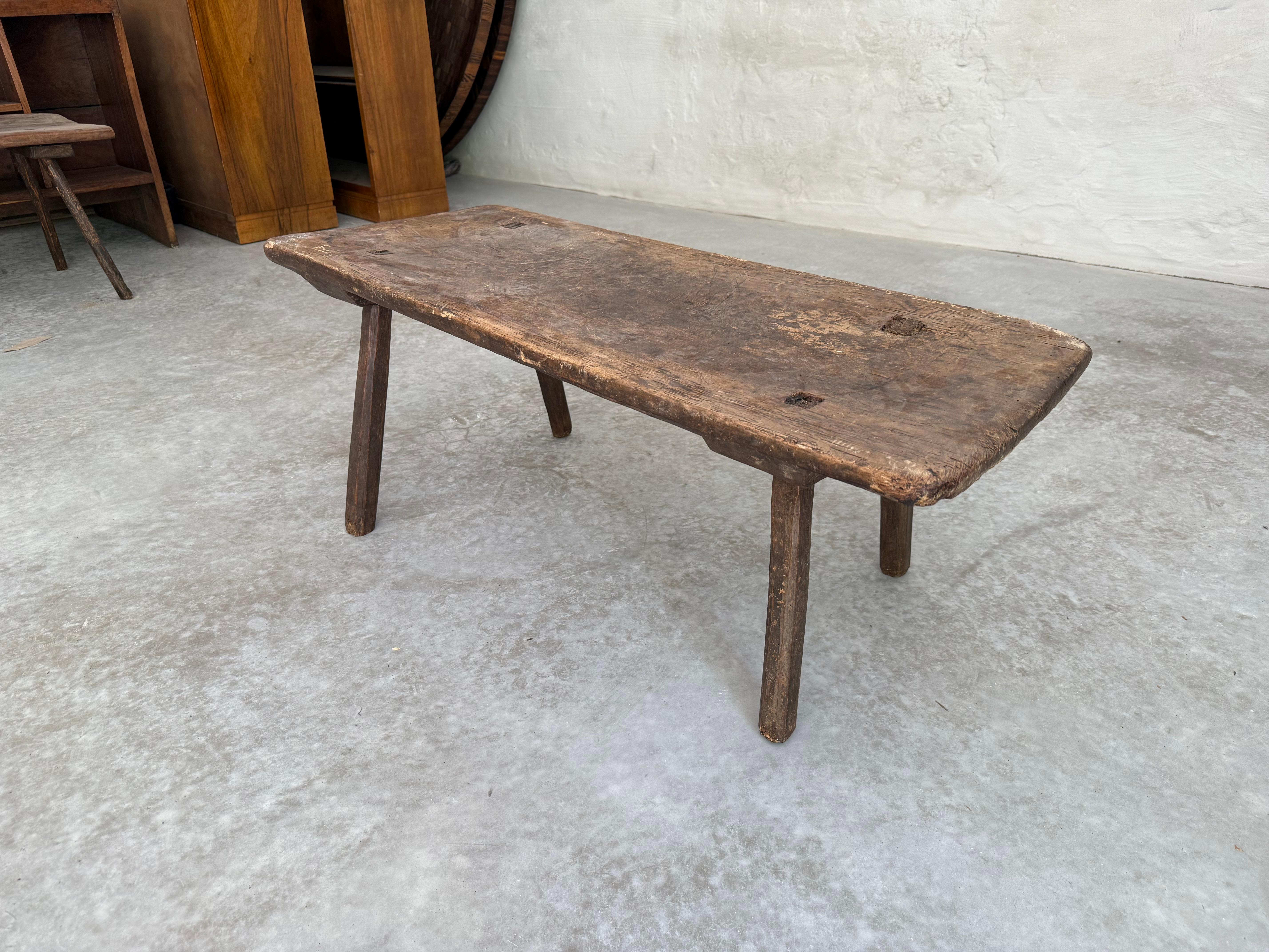 An Italian single-board top wooden coffee table from the 19th century. This antique table from Italy features a single board wood top, rectangular in shape with smoothed edges. It is raised on four legs which cant in outwardly fashion. The wood has