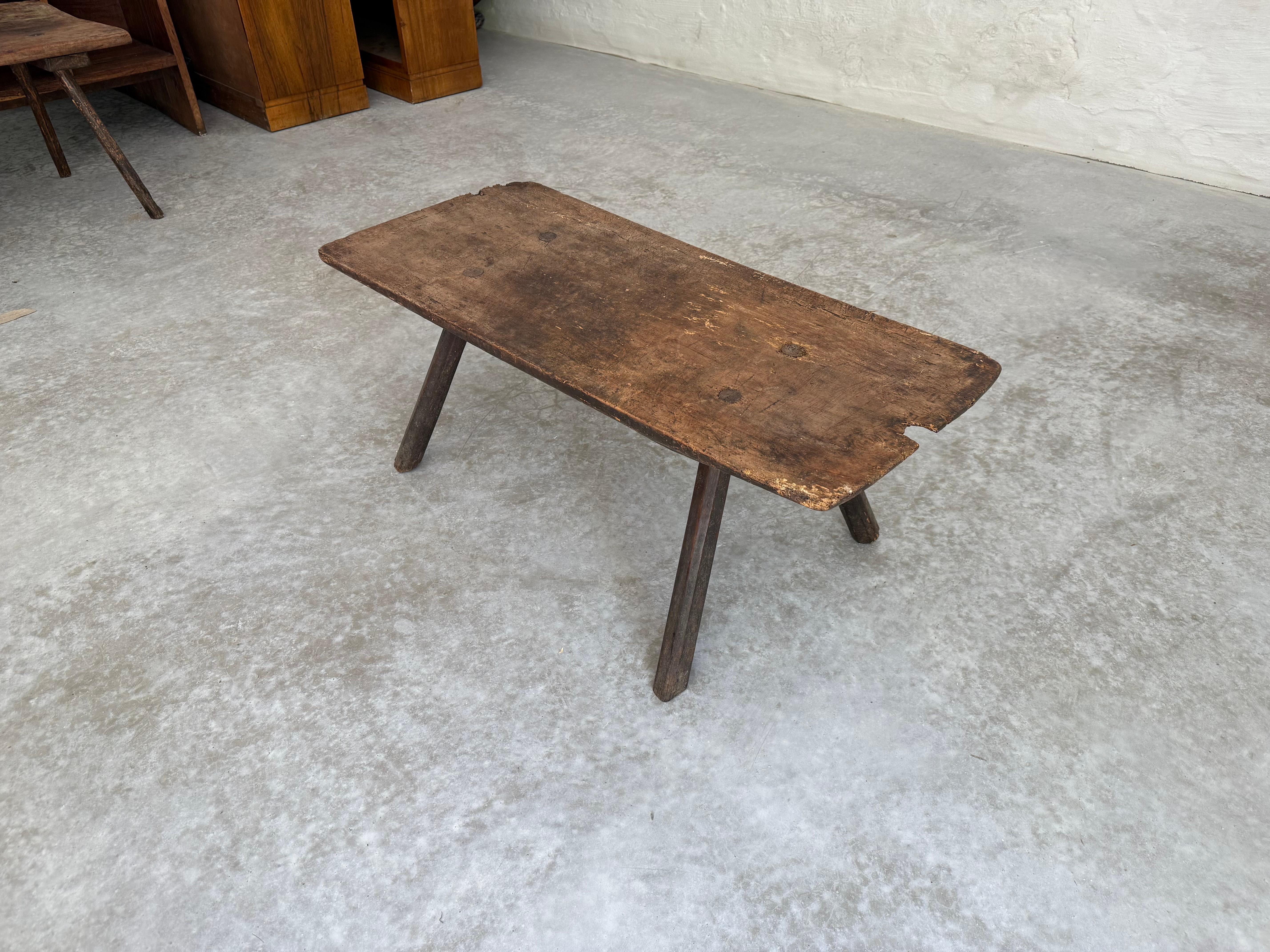 An Italian single-board top wooden coffee table from the 19th century. This antique table from Italy features a single board wood top, rectangular in shape with smoothed edges. It is raised on four legs which cant in outwardly fashion. The wood has