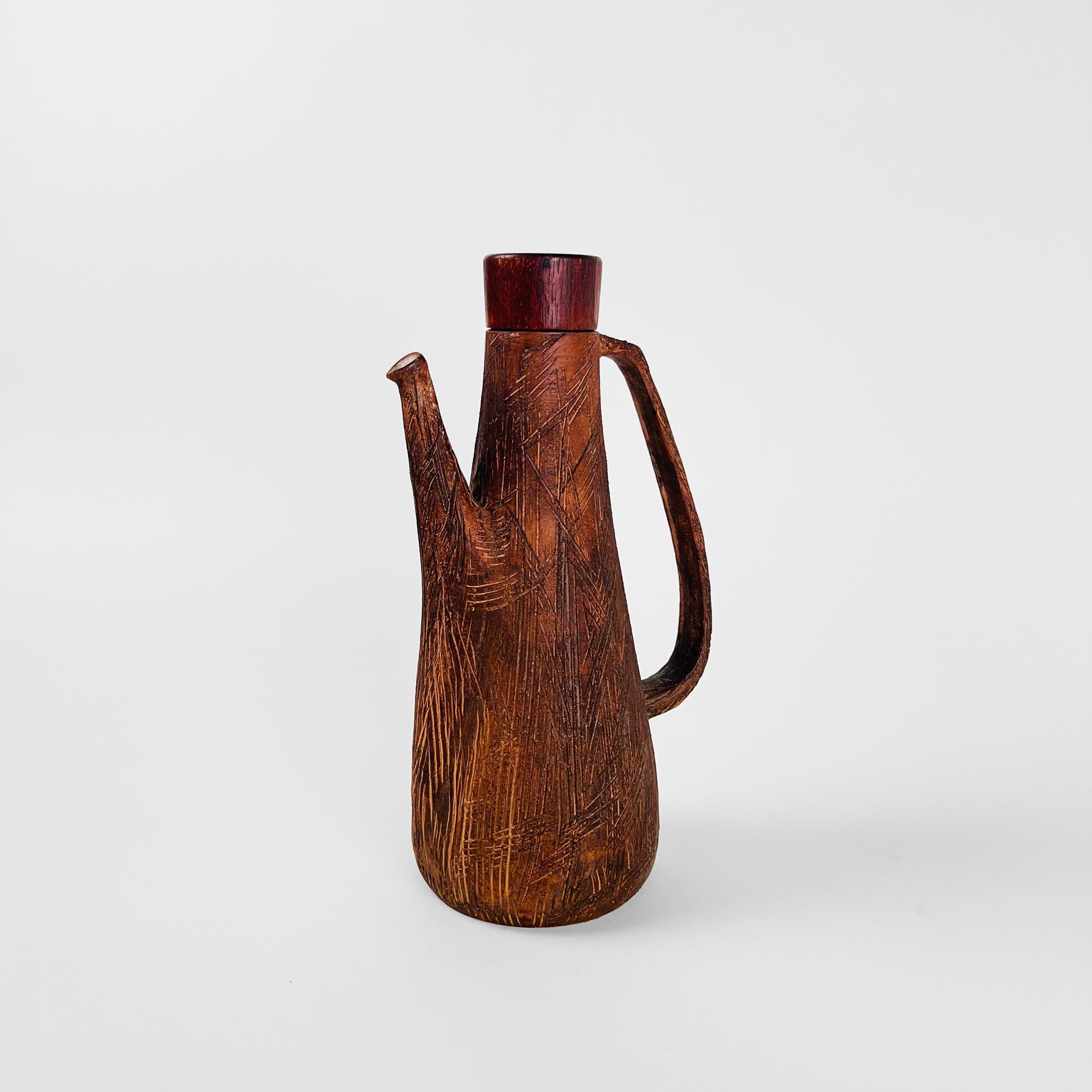 Rustic Japanese pitcher with wooden lid. Exterior finished in mate dark brown glaze with combed texture. Interior finished in white gloss glaze.