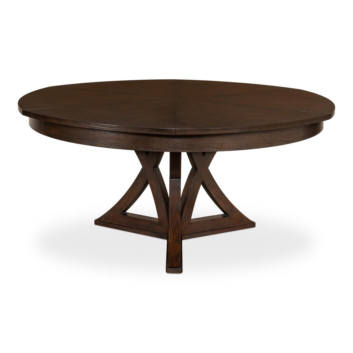 Une table à manger ronde à rallonge en chêne rustique de style transitionnel. La table en chêne dans notre finition chaude est une excellente combinaison de style classique et de commodités modernes. Fermée, elle mesure 64