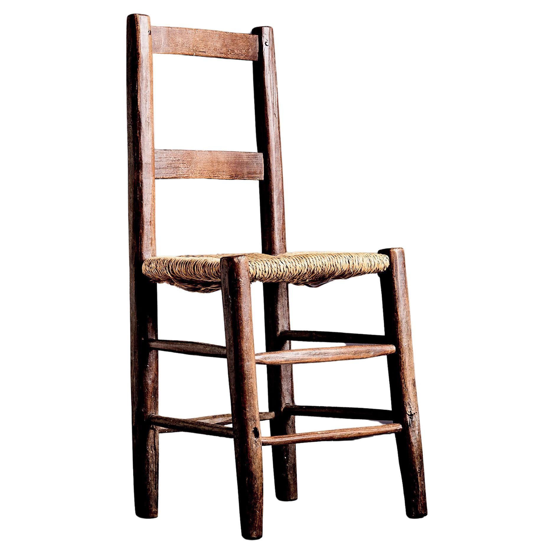 Rustic ladder-back chair with straw seat France early 20th century For Sale