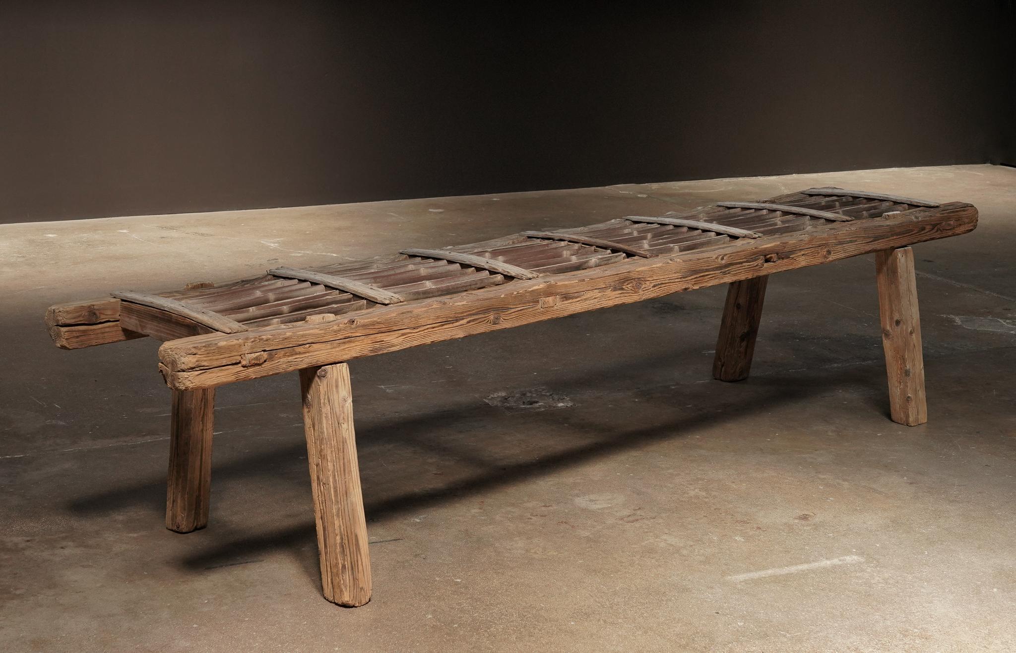 A rustic early 20th-century ladder bench from Japan, marked by its elongated form and beautiful patina. Its unique scale and understated charm make it a versatile piece in the space.