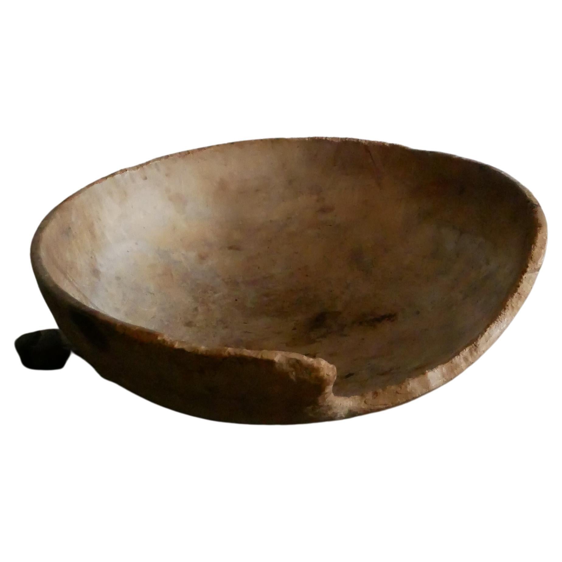 A big beautiful wooden bowl from 1900-century.
It has a light soft color and a smooth surface, at one time long ago small house-mices has eaten a way on the side. This ads character to the piece. 
This was a common problem in rural Scandinavia at