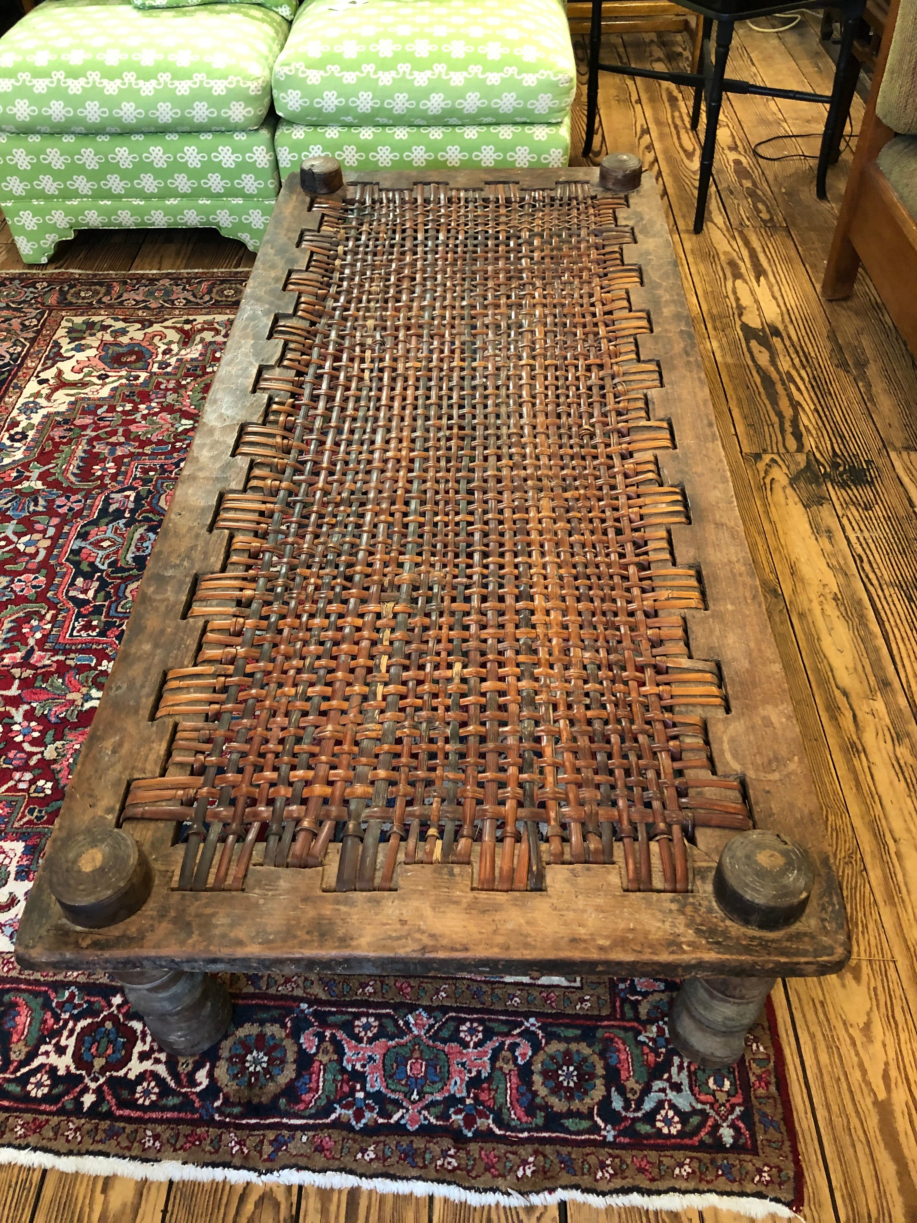 Large rectangular rustic handmade Tibetan cot that makes a statement as a low character rich coffee table. The wood is wonderful rough hewn and the top is a woven rattan.