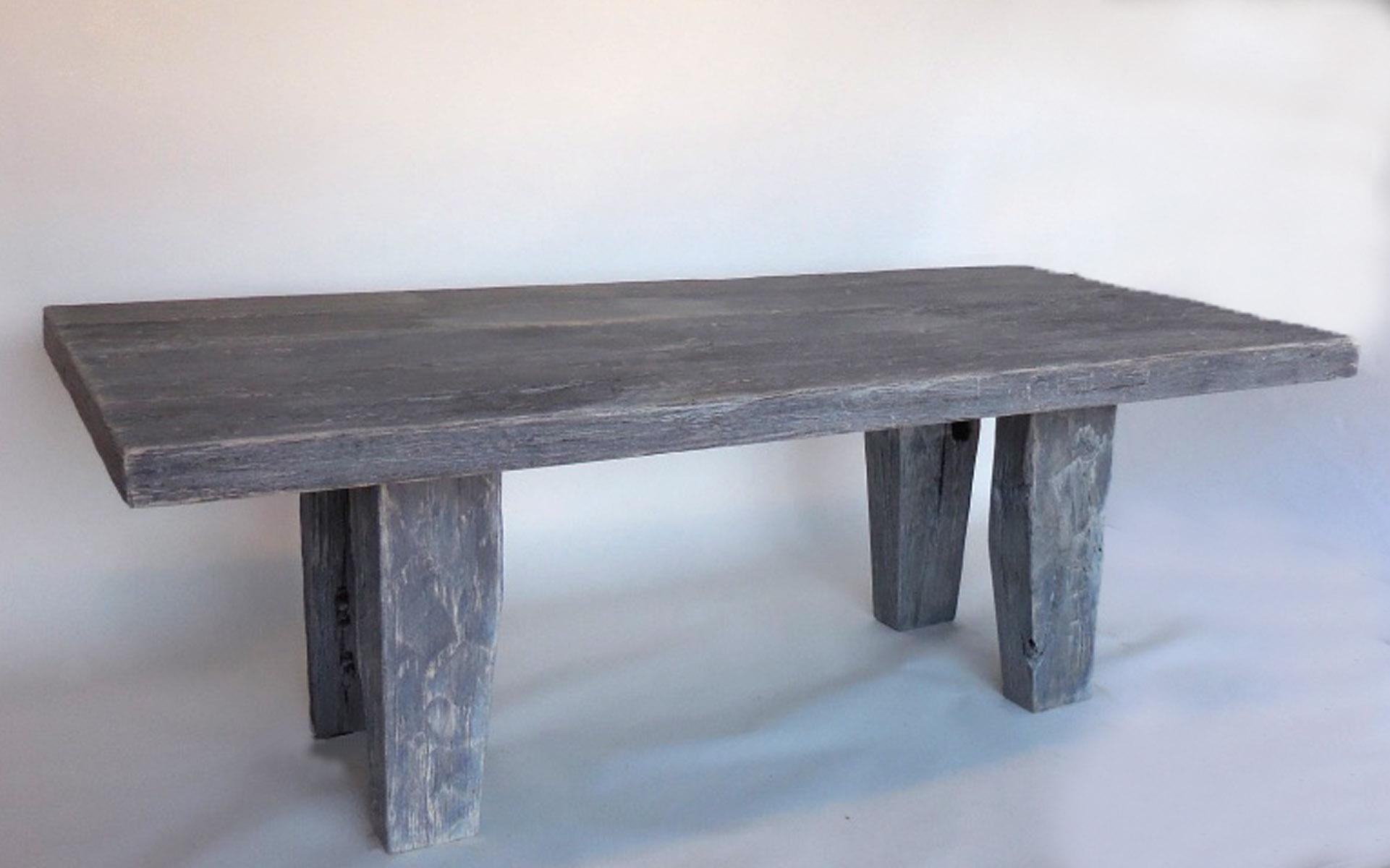 Sculptural dining table, made from reclaimed hand hewn cypress wood. Light grey beige finish. Large legs taper to the floor. The wood is textured but smooth to the touch. Thick top and legs. From Guatemala.

 