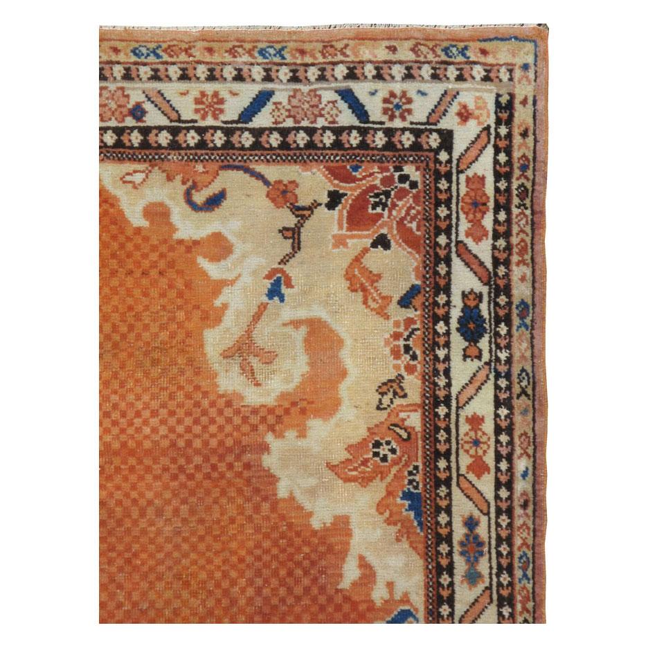 A vintage Persian Mahal gallery rug handmade during the mid-20th century with large curvilinear beige corner spandrels bordering a mosaic pattern in rust and orange. The mosaic pattern continues to become a tiny colorful medallion.

Measures: 4'