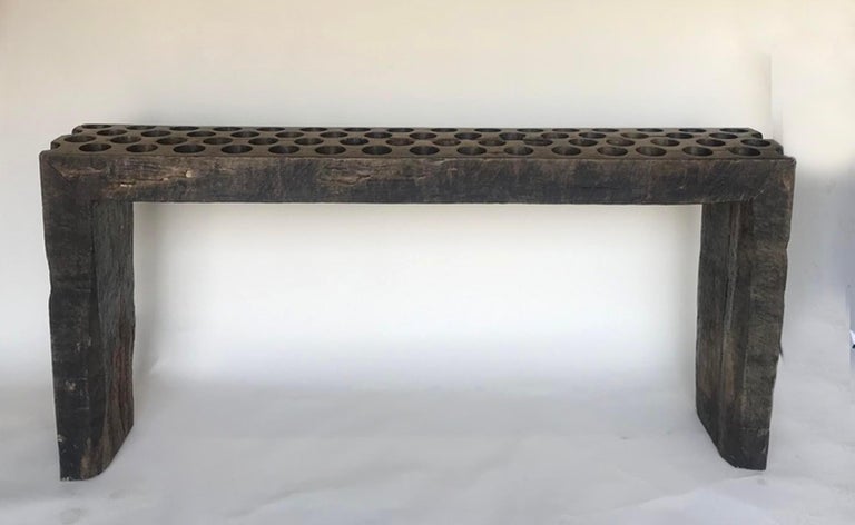 This rustic modern waterfall console was constructed from an old huge sugar mold (panalera) from Guatemala. The top and legs are 5 inches thick. The 3 inch holes are small enough where you can use it as a flat surface for lamps and accessories.