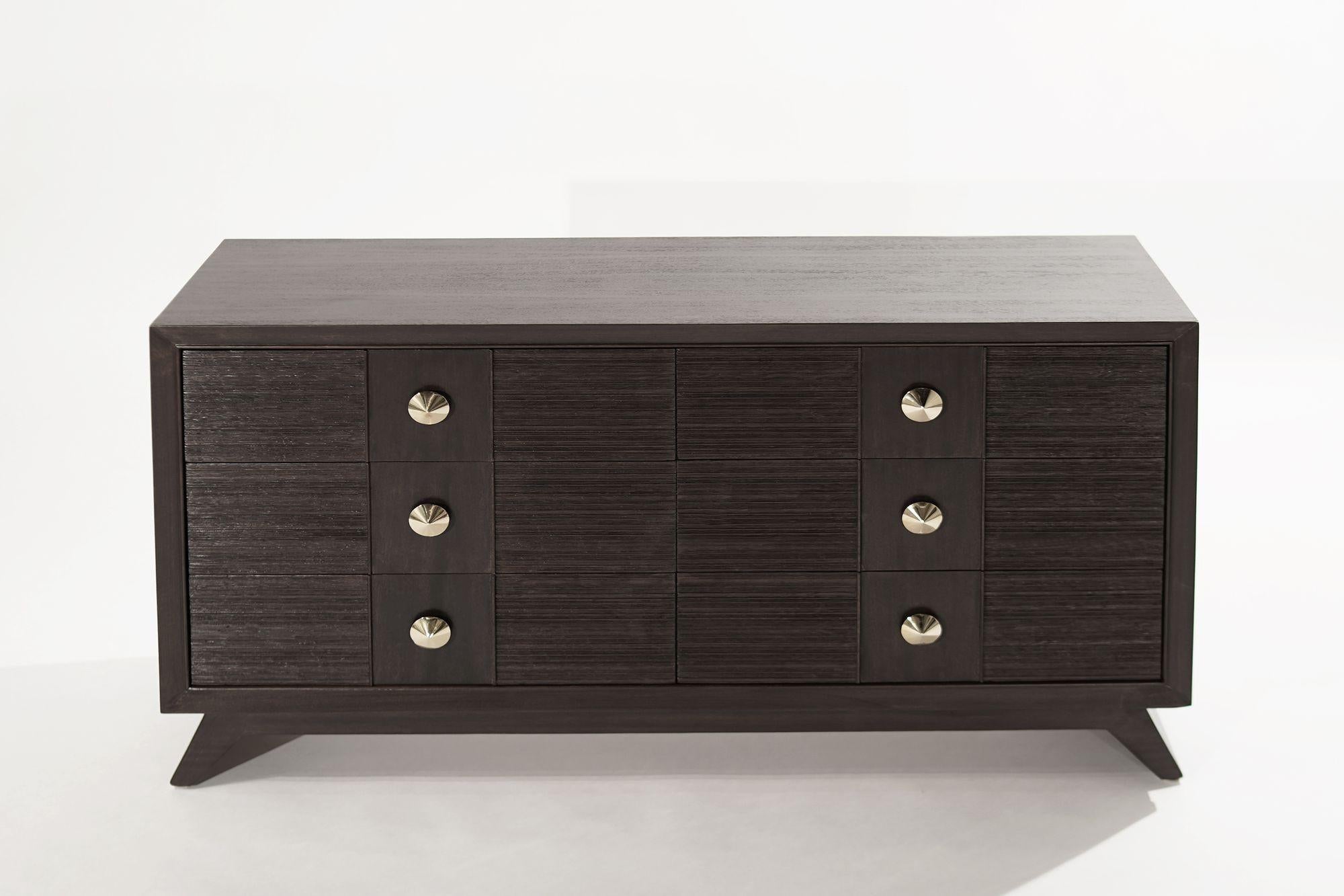 A rare dresser designed by Paul Frankl for Brown Saltman, United States, circa 1950-1959. The oak case has been completely restored in our dark oak finish, this design features textured drawers highlighted by hand-polished brass hardware. 
 
Other