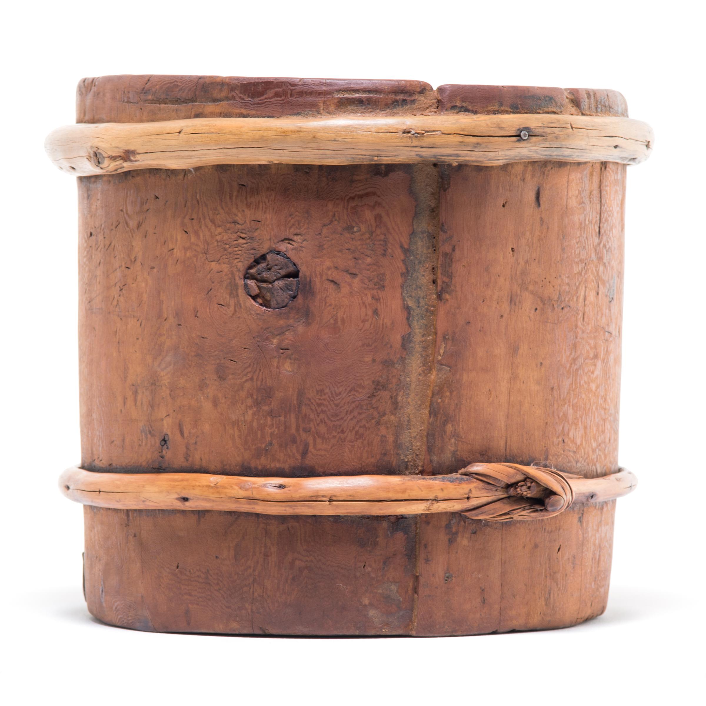 This beautiful grain container was made over a century ago in Mongolia. It was made to last: the sturdy pine wood slats tightly joined, with the forever knots helping to secure them in place. The container shows some signs of wear that attest to its