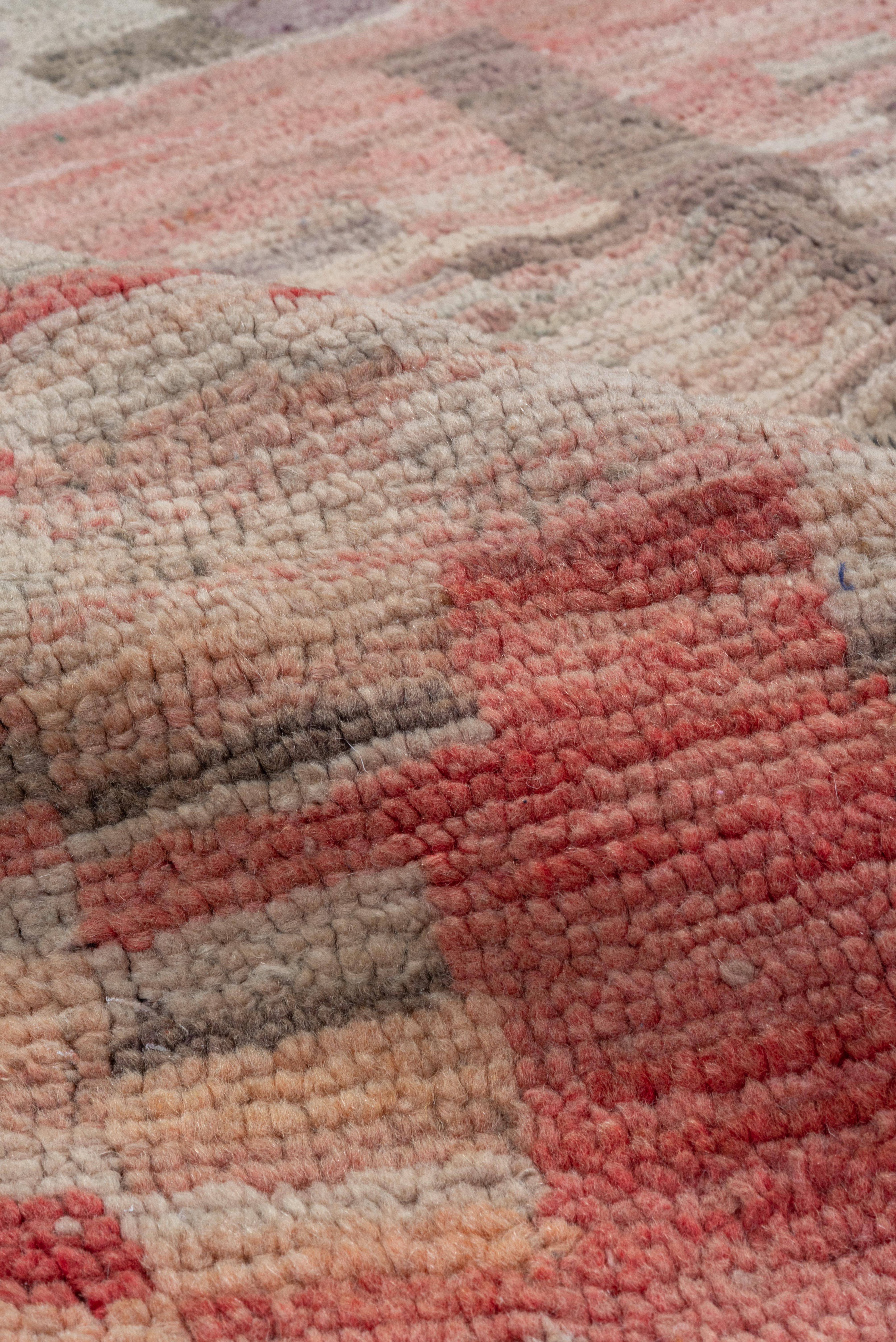 This coarsely woven, high pile small scatter shows an abstract rustic design of chessboard squares, wavy vertical bands and lots short tonal streaks, all in reds, straw, old gold, tan, ecru and brownish-rose. Intact end finish plainweave bands and