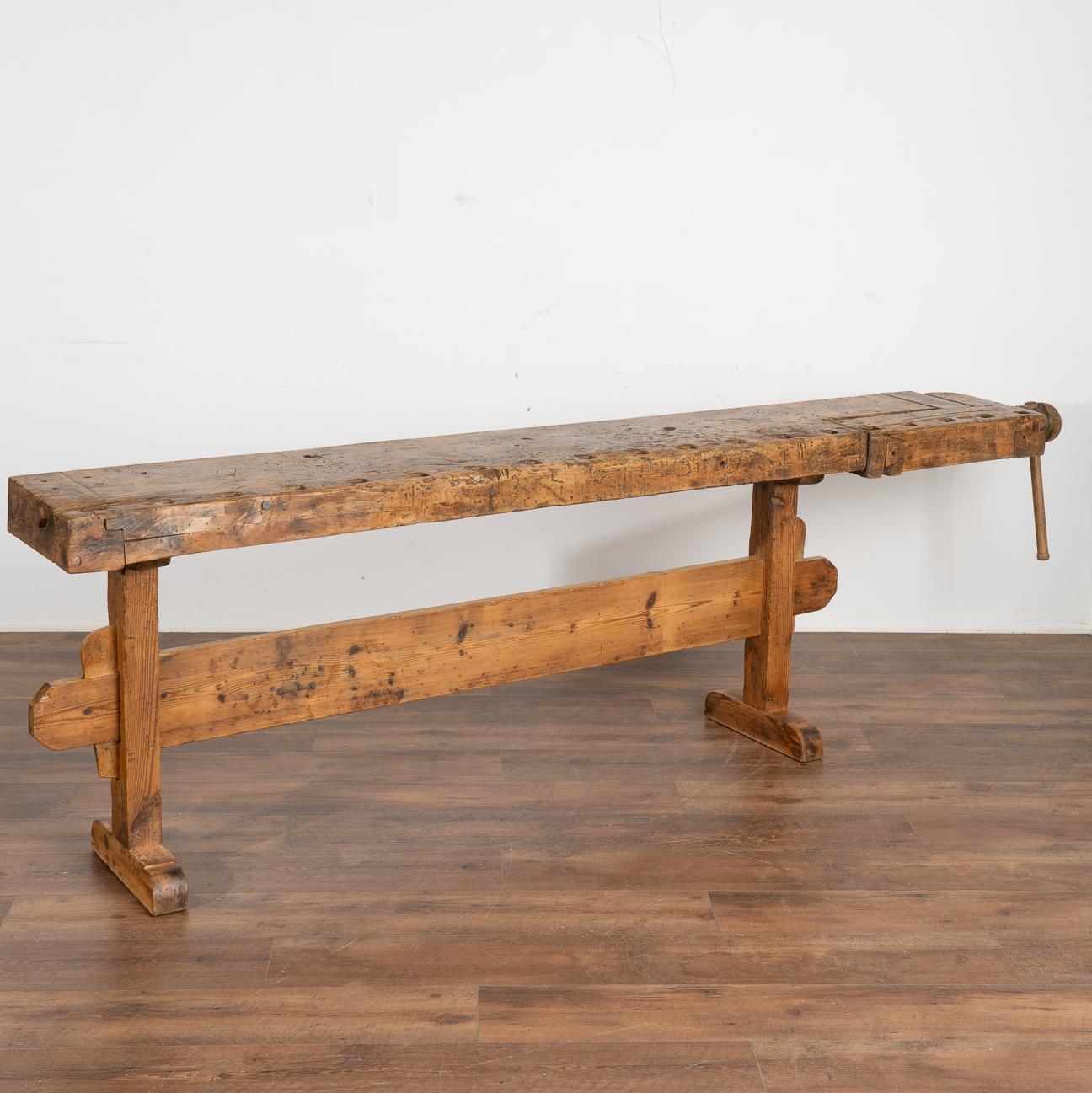 The dark patina of this old carpenter's workbench is a reflection of its age and years of use. Every ding, scratch, gouge and stain enrich its character and appeal.
This rustic work table is narrow, at only 13