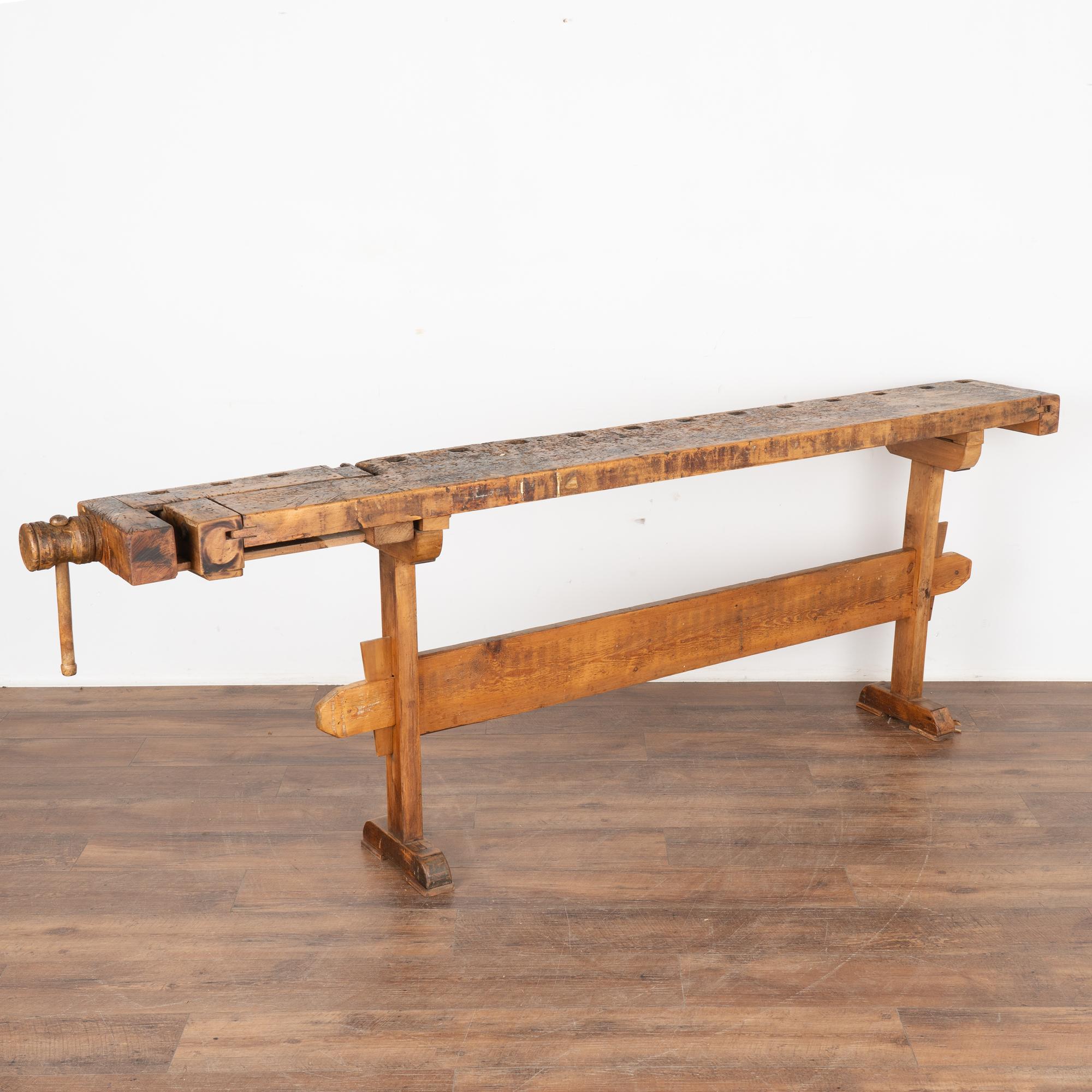 The worn patina of this old carpenter's workbench is a reflection of its age and years of use. Every ding, scratch, deep gouge and stain enrich its character and appeal.
This rustic work table is narrow, at only 11.5
