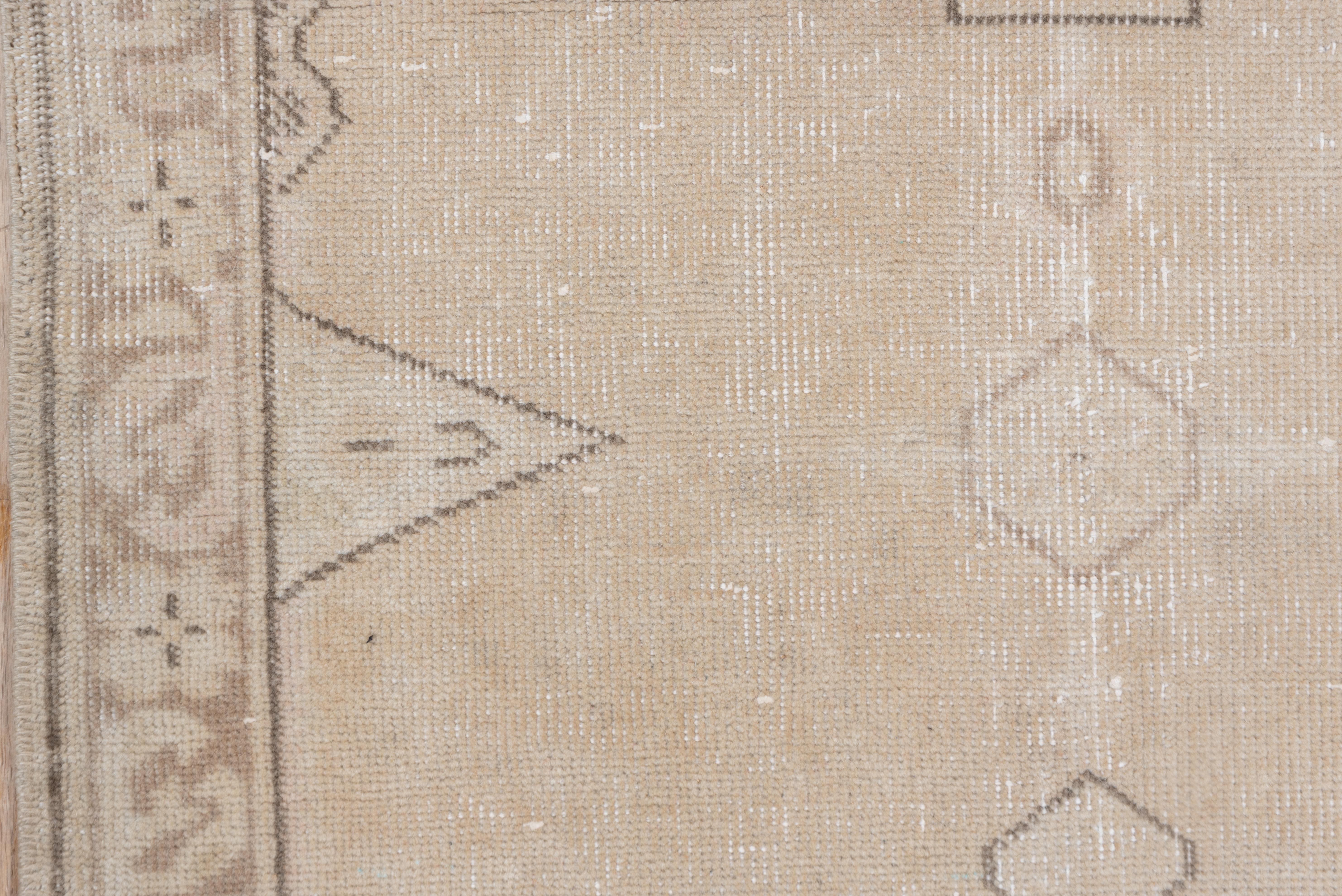 This light colored rustic Anatolian runner shows an open sandy straw to pale buff field centered by a loose pole medallion of cartouches, octagons and a cruciform element. Caucasian style. Taupe rosette border.
