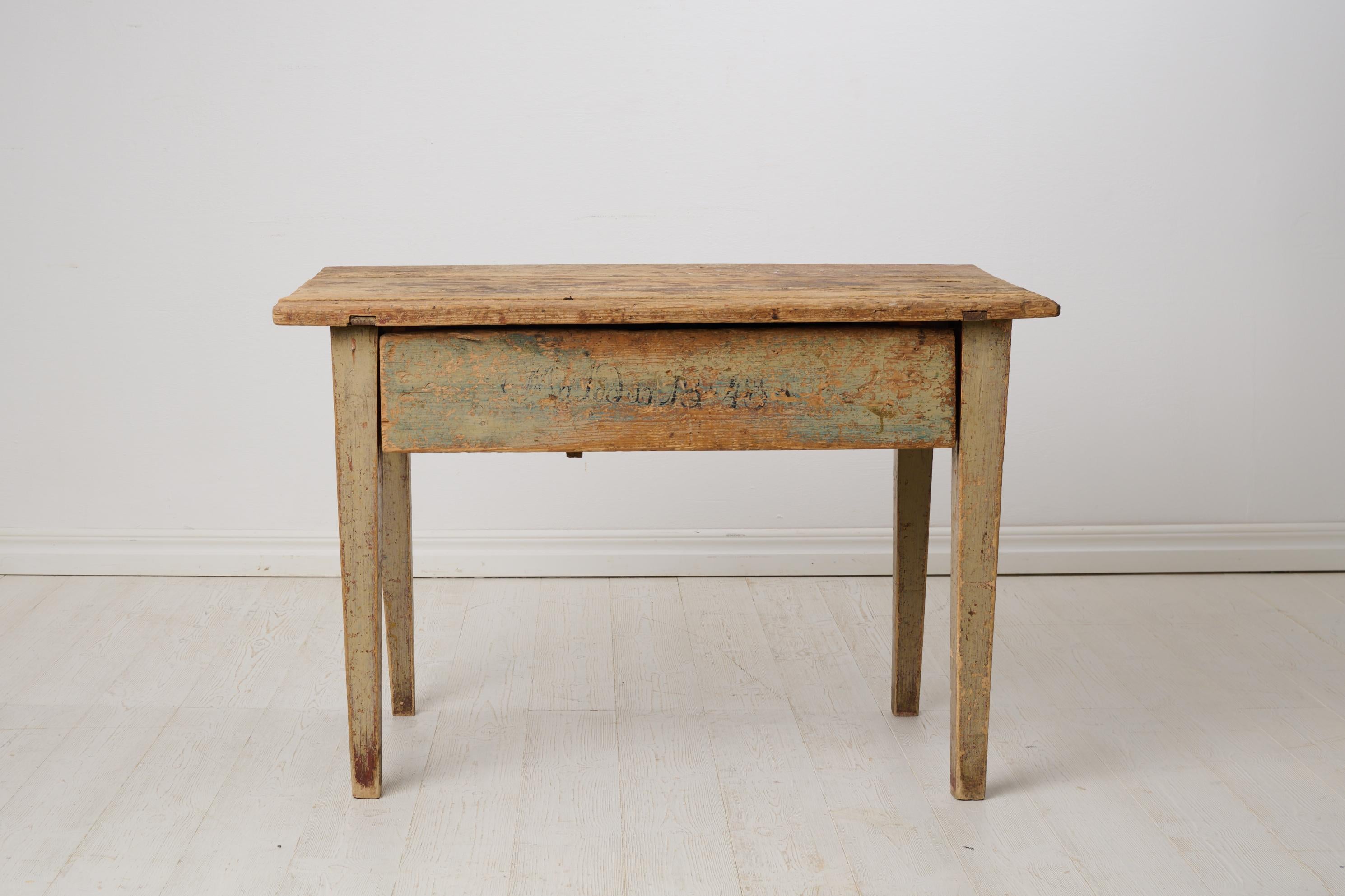 Table de ferme rustique du nord de la Suède, fabriquée à la main en pin massif. La table date d'environ 1840 et est dans un état d'origine intact. Il présente la peinture d'origine et les traces d'un jeu d'initiales et d'une datation, 1848, sur le