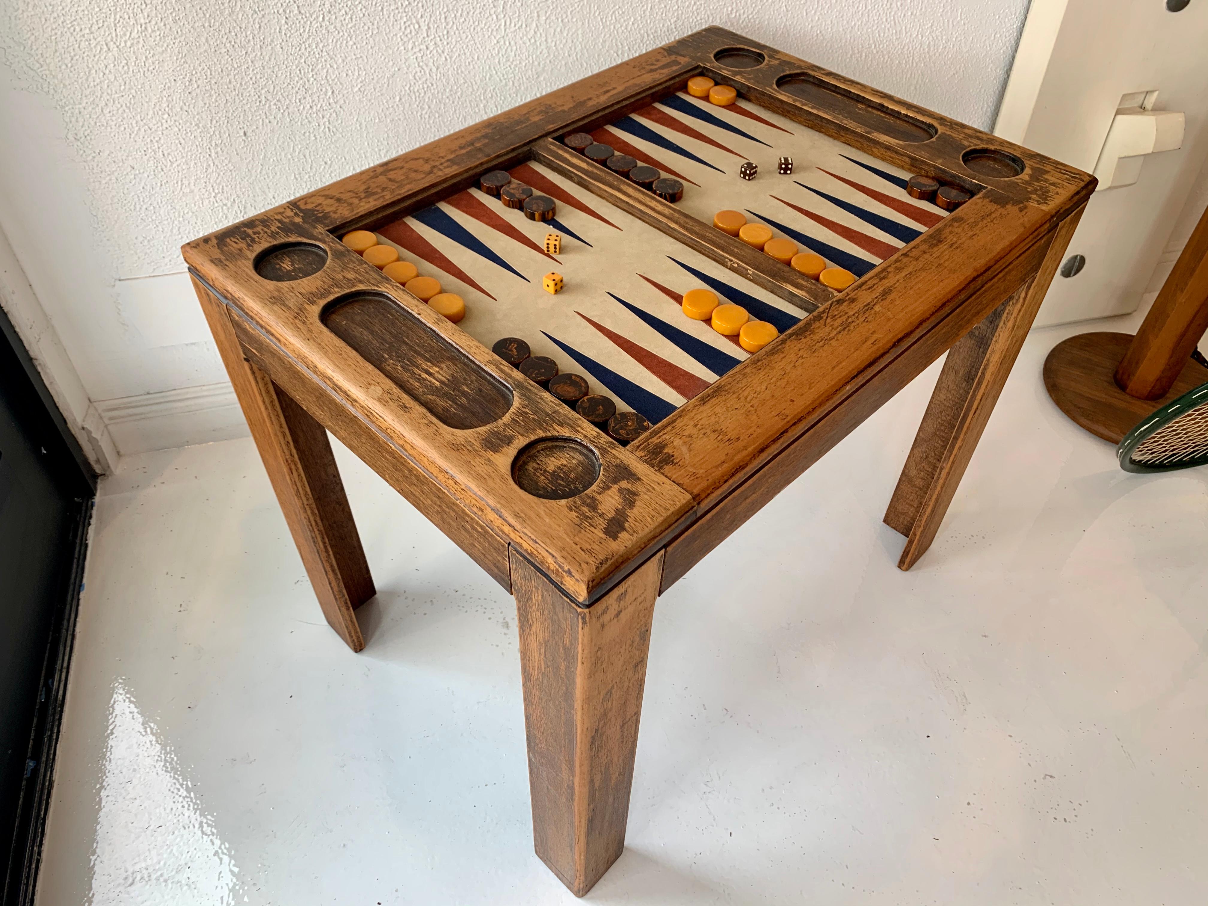 Classic oak backgammon table in original rustic oak finish.. Suede game board with red and blue triangles. Smoked glass top, bone dice and original Bakelite game pieces included with purchase. Great colors and the perfect scale.