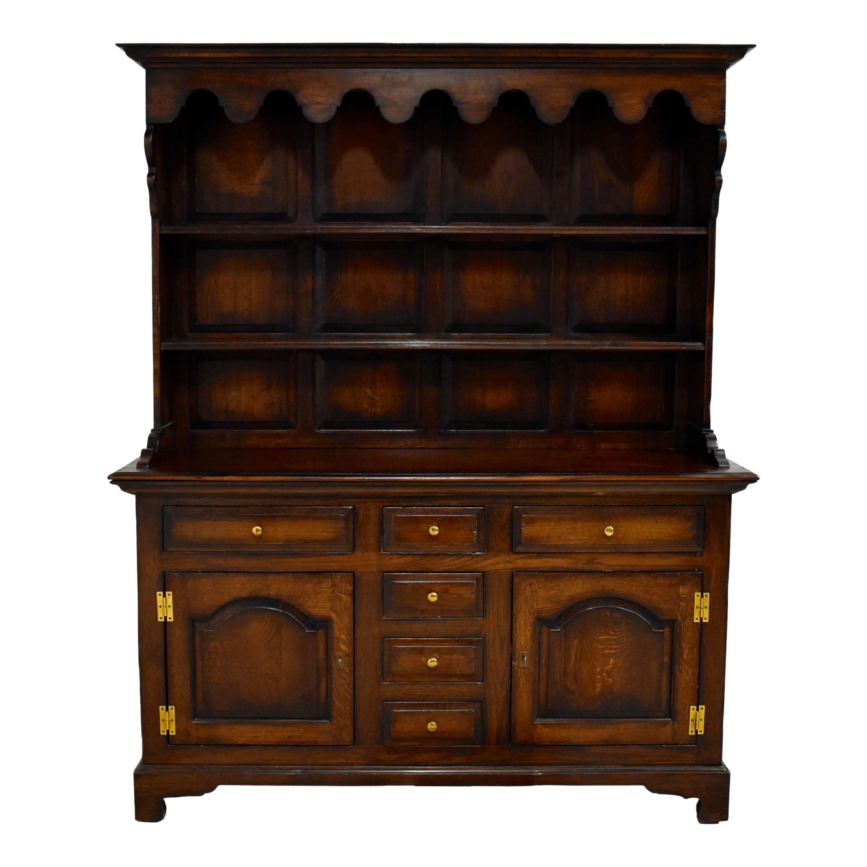 This charming vintage cupboard is crafted from European oak and finished with a staining technique that darkens the edges, creating depth and an aged appearance. Intentional grooving in the wood before the cupboard was stained gives it a rustic