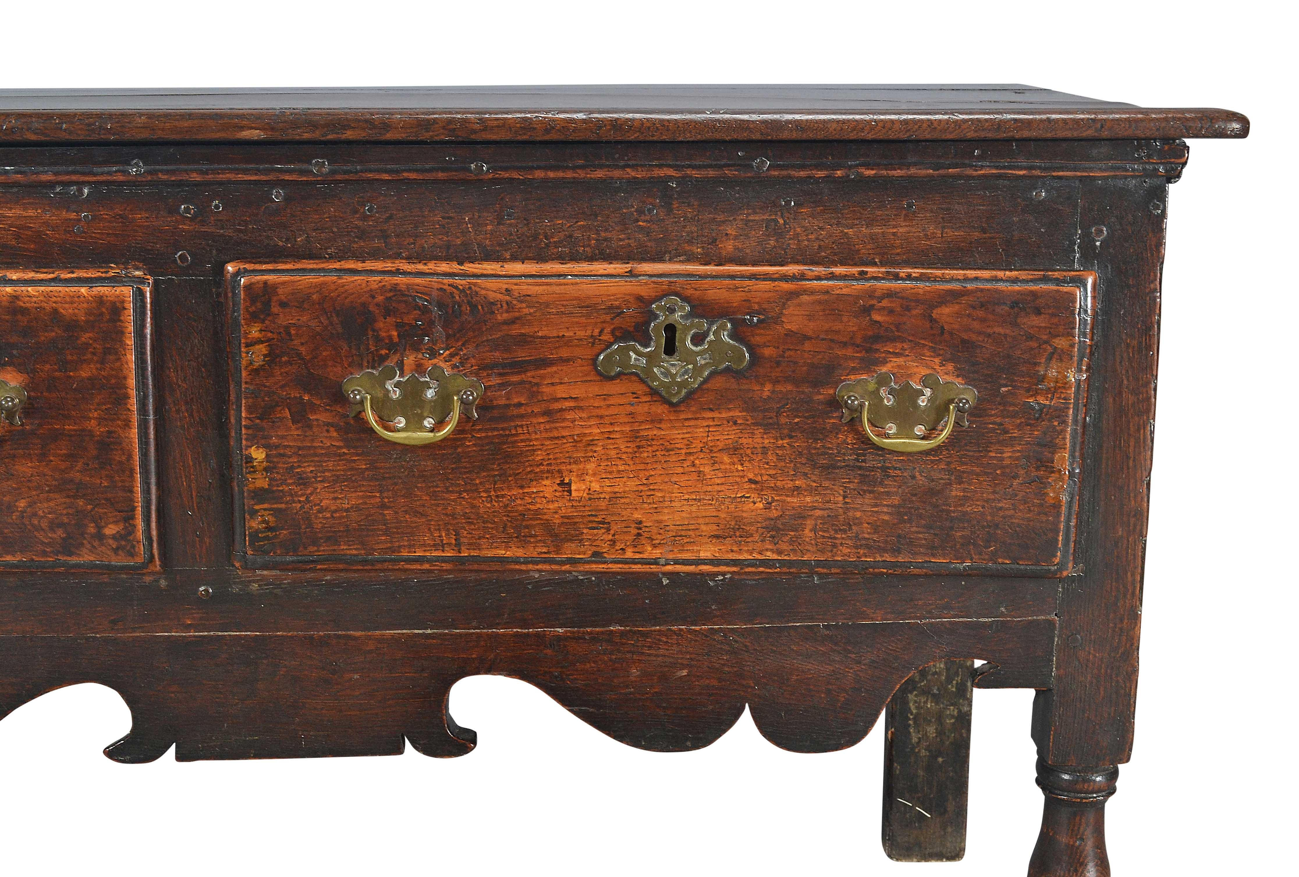 Un comò in Oak che poggia su gambe tornite a blocco e a balaustro. Con tre cassetti sopra un grembiule sagomato. Patina intatta. Maniglie sostituite.